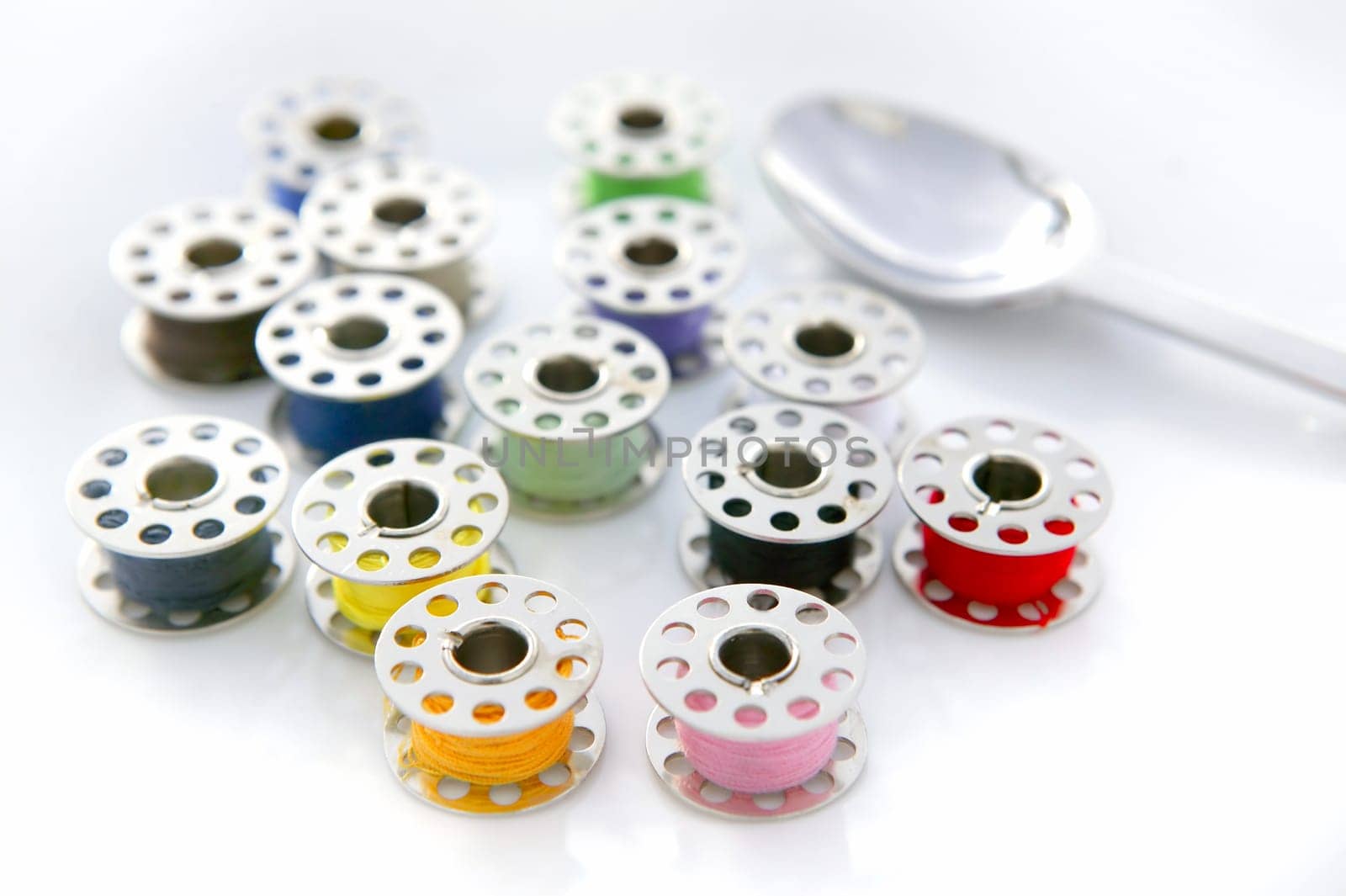 surreal meal of color sewing reels with spoon over shite