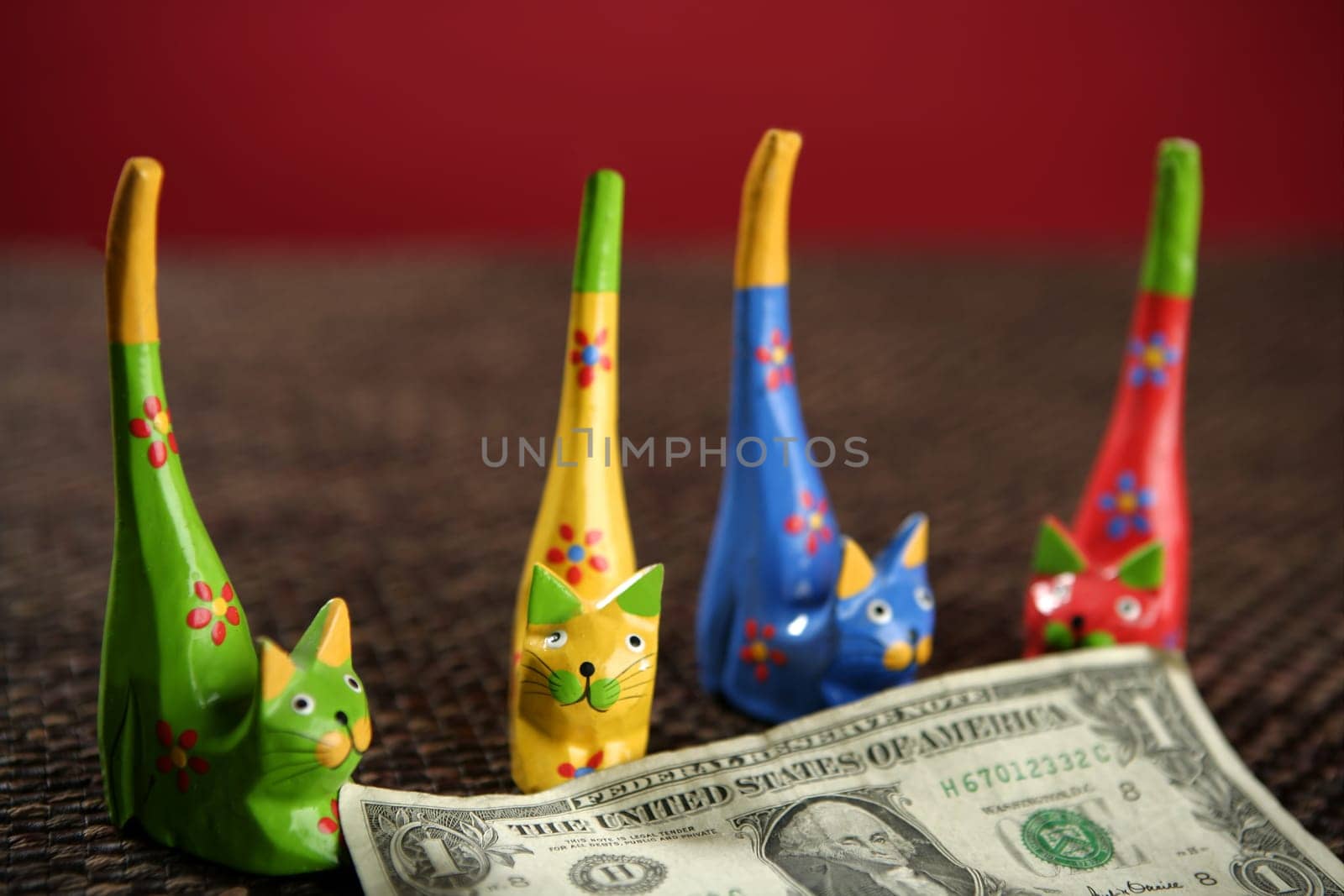 four handcraft cats arroun one dollar note, business teamwork metaphor