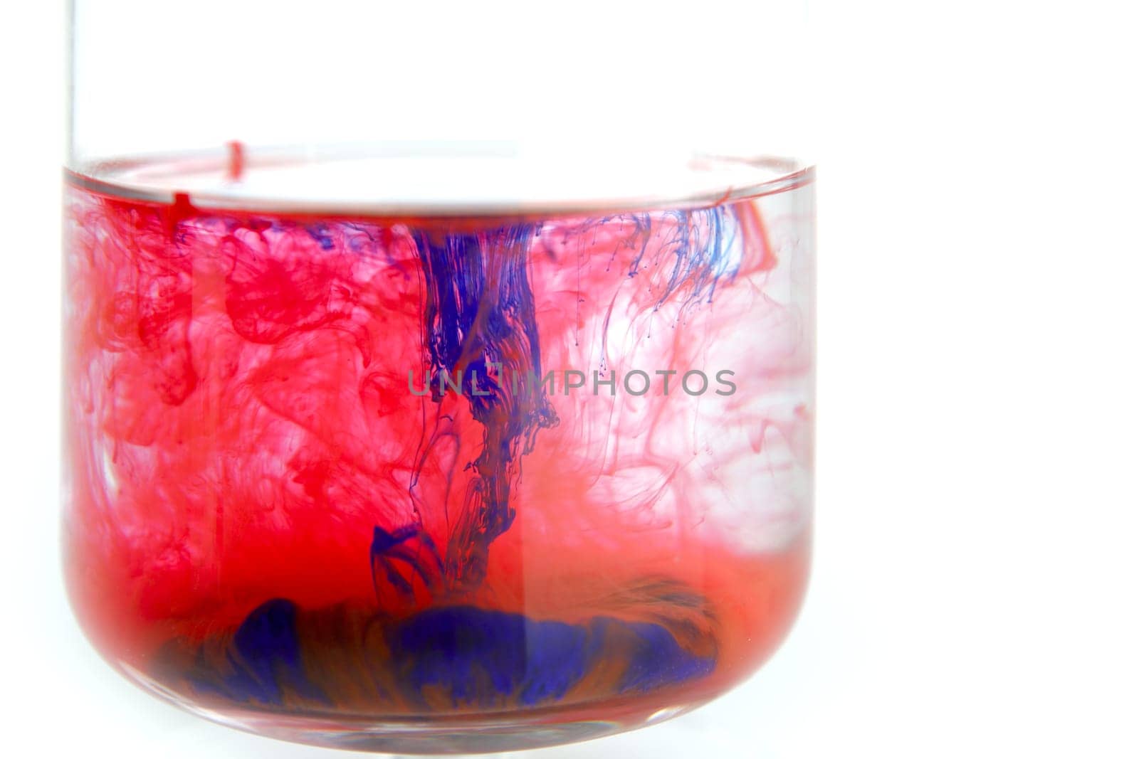 Color pigments into the water making clouds, over white background
