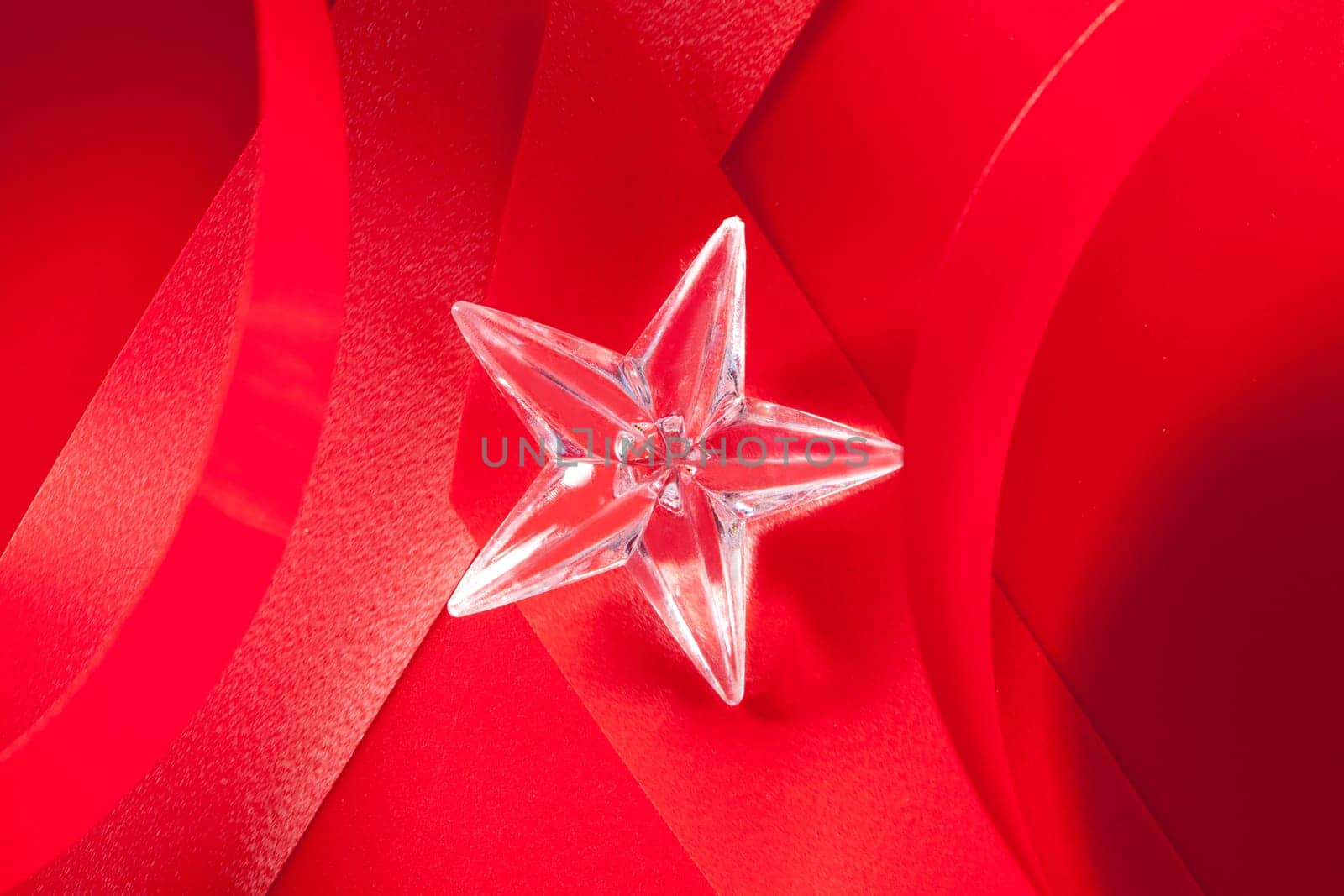 christmas glass star on red ribbon background