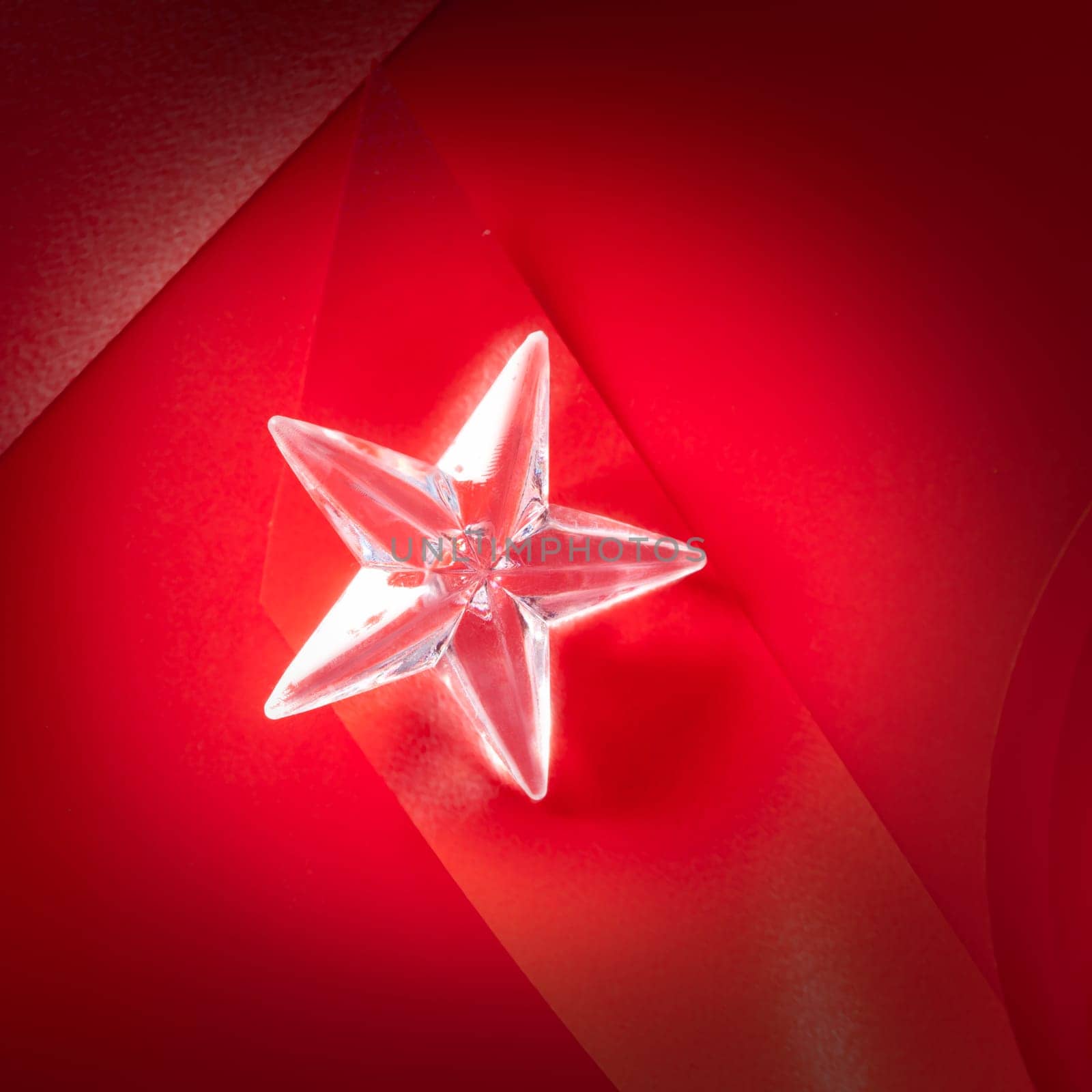 christmas glass star on red ribbon background