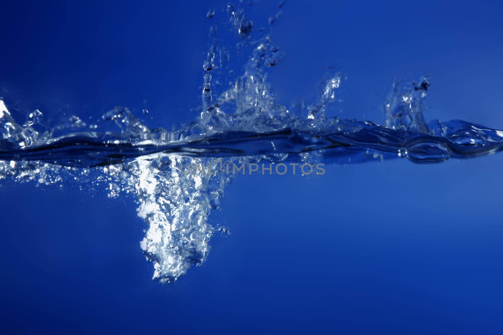 Blue water falling like splash close up macro side view