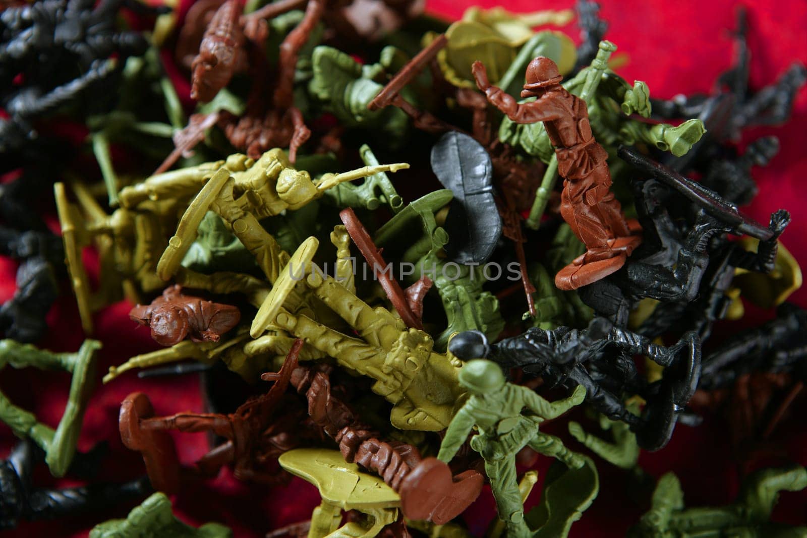 Metaphor of dead plastic toy war soldiers on a red bloody background