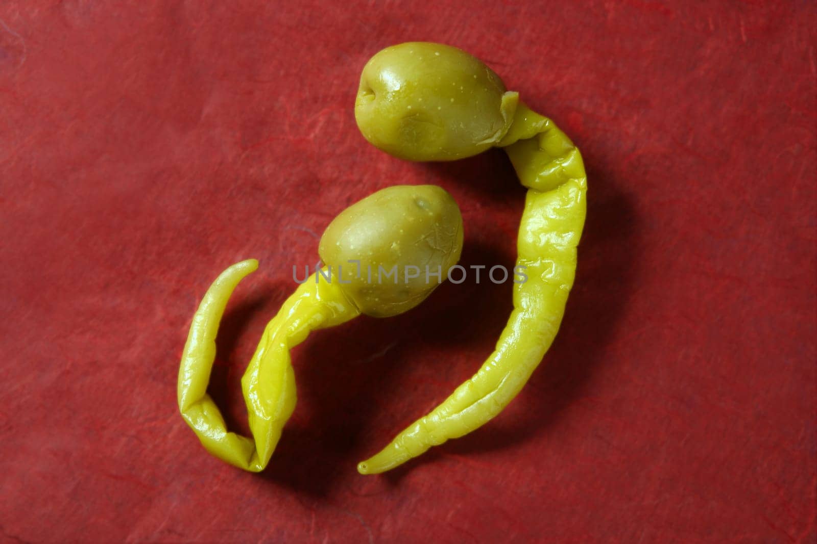 Hot olive with pepper, typical spanish tapas over red background