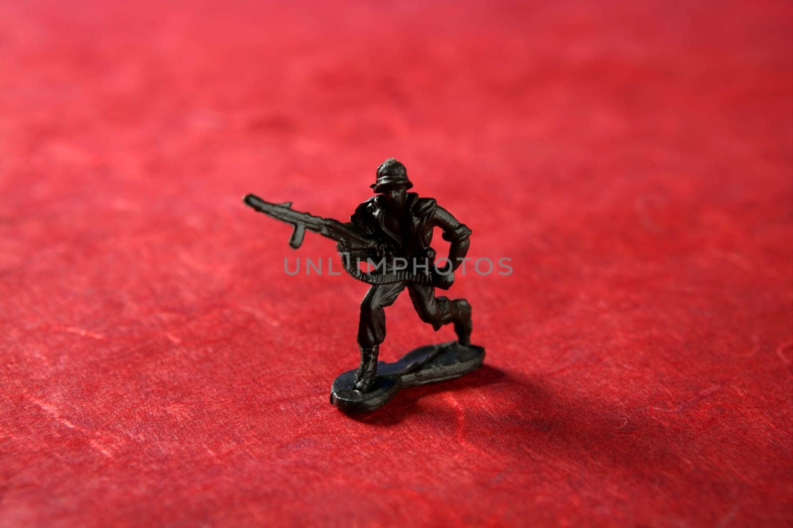 Plastic toy soldier over red background, war metaphor