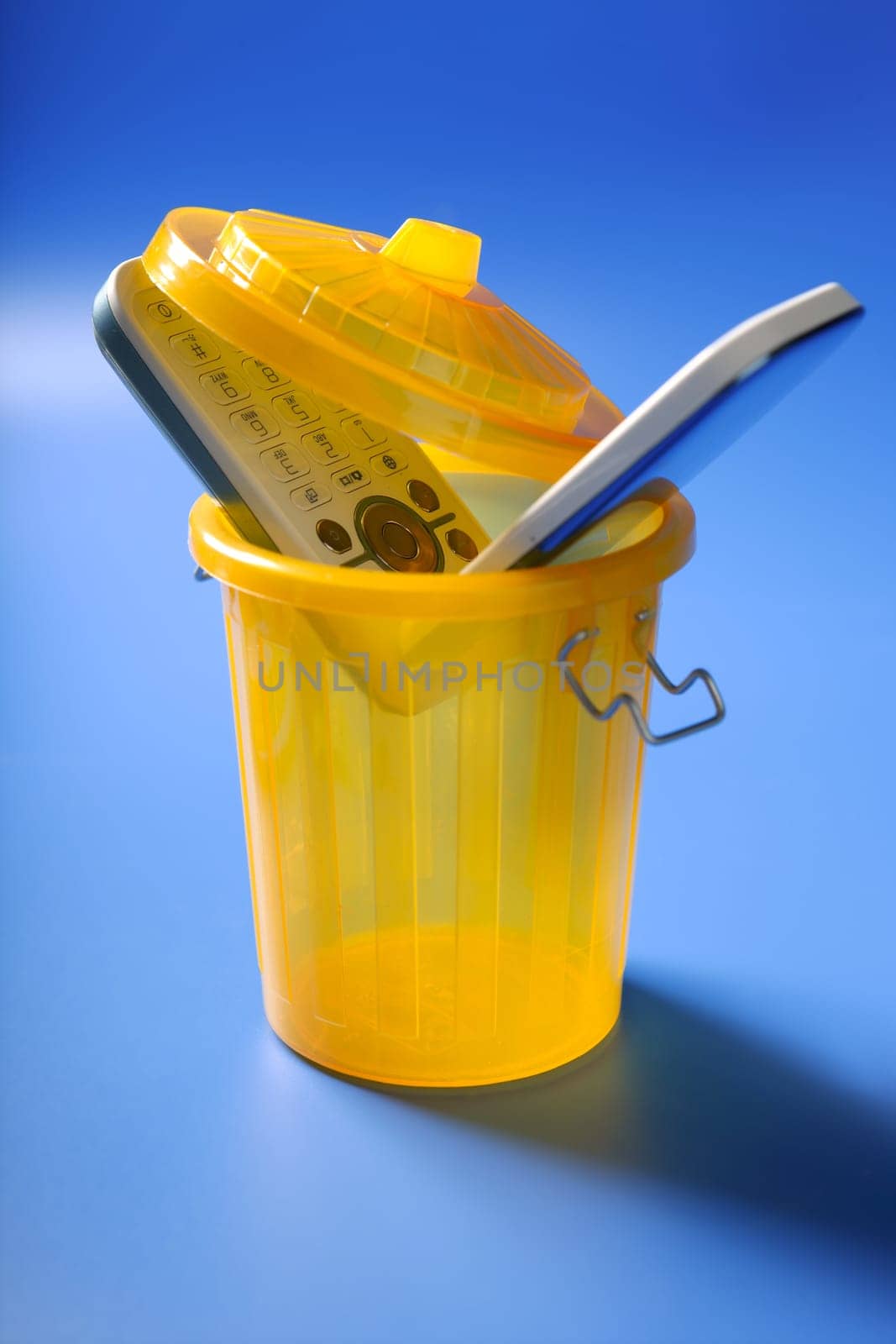 Mobil cell phone on the trash, fed up of communication metaphor
