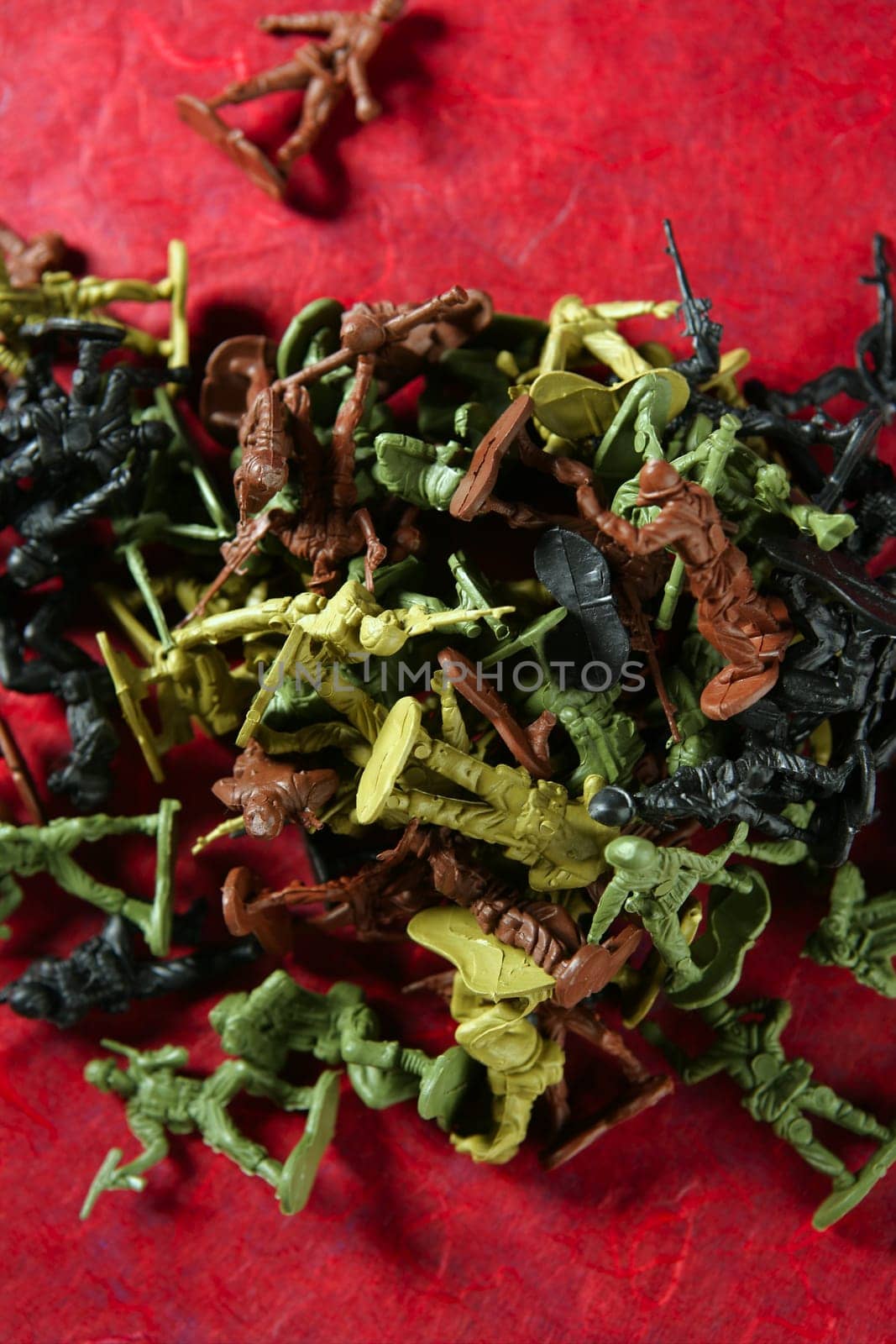 Metaphor of dead plastic toy war soldiers on a red bloody background