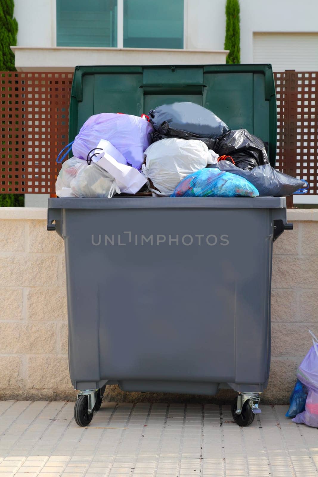 Trash garbage full of bags container in street