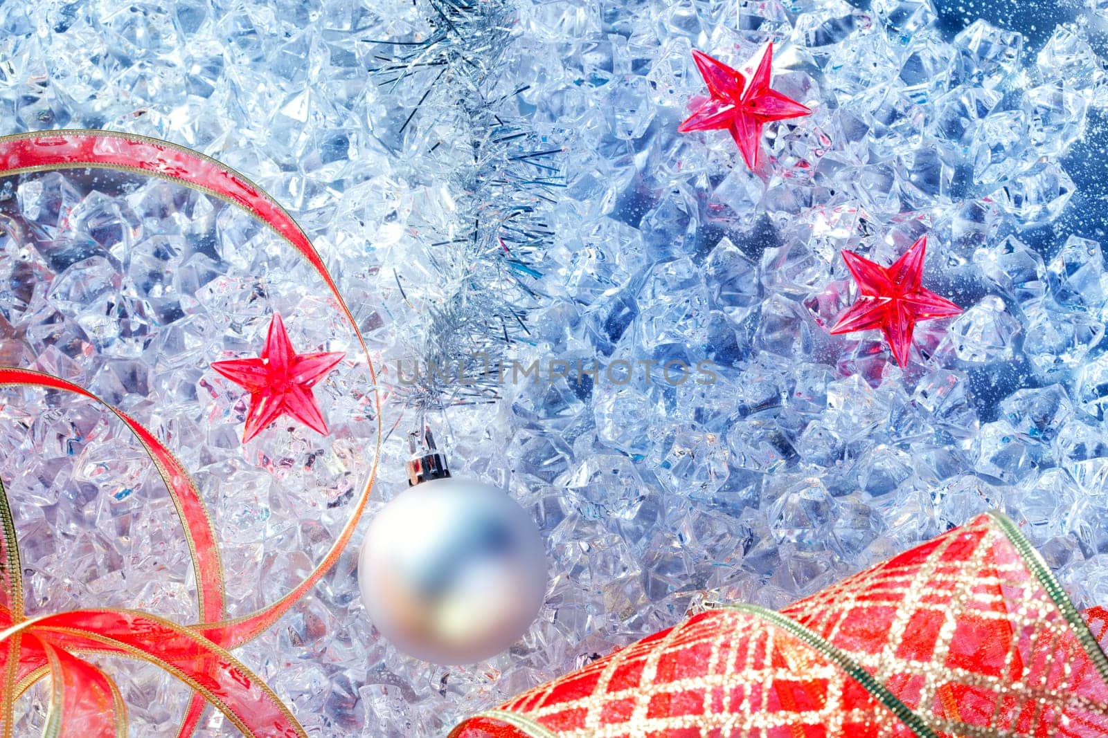christmas silver bauble and red ribbon on ice with red star