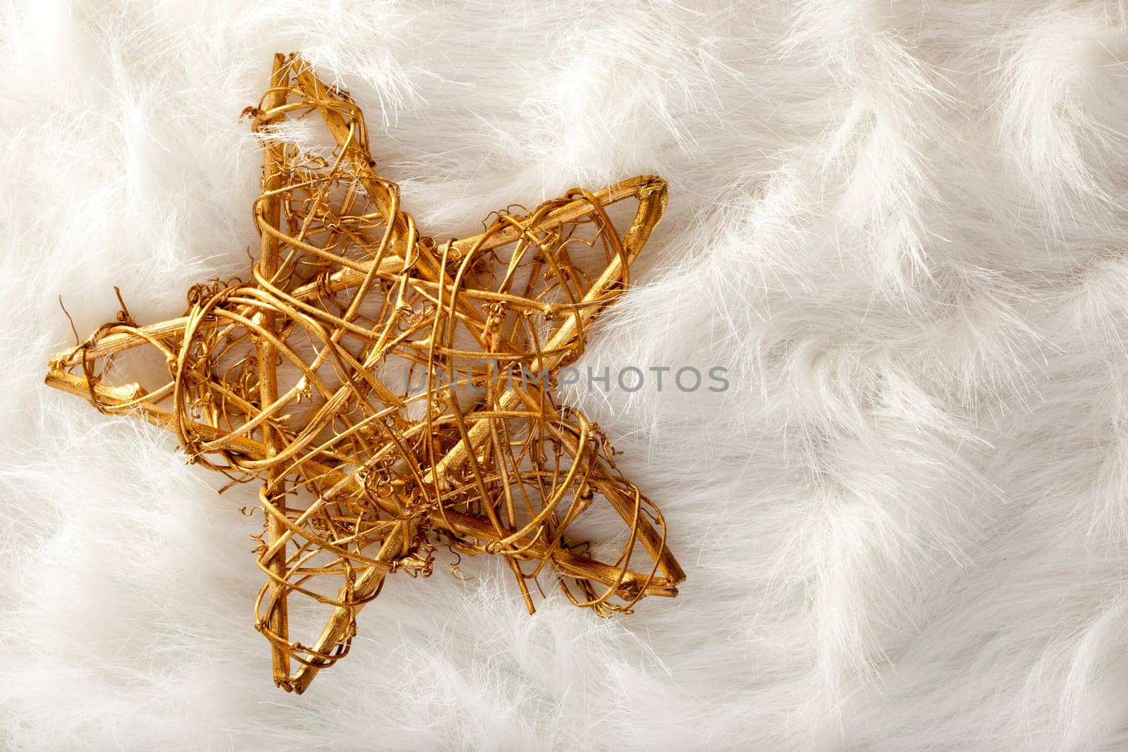 Christmas golden star over white fur background