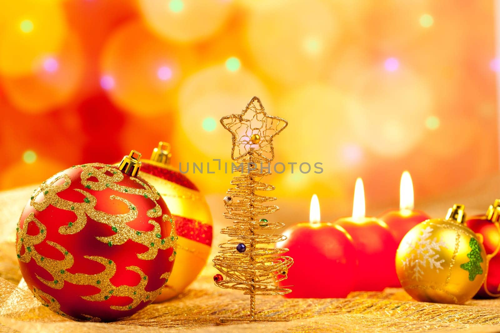 Christmas golden tree with baubles and candles in blur lights