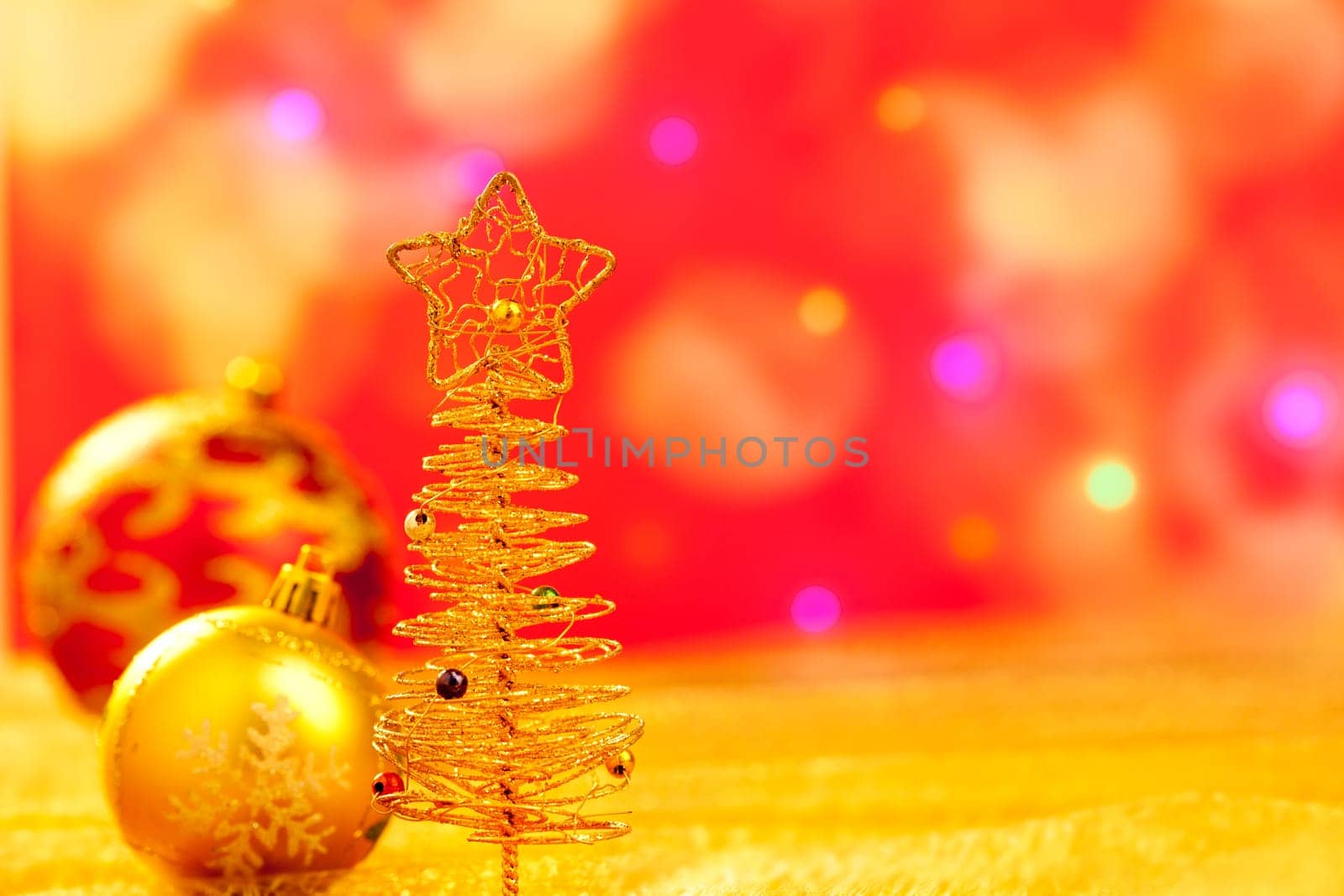 Christmas golden tree with babubles in blur lights background