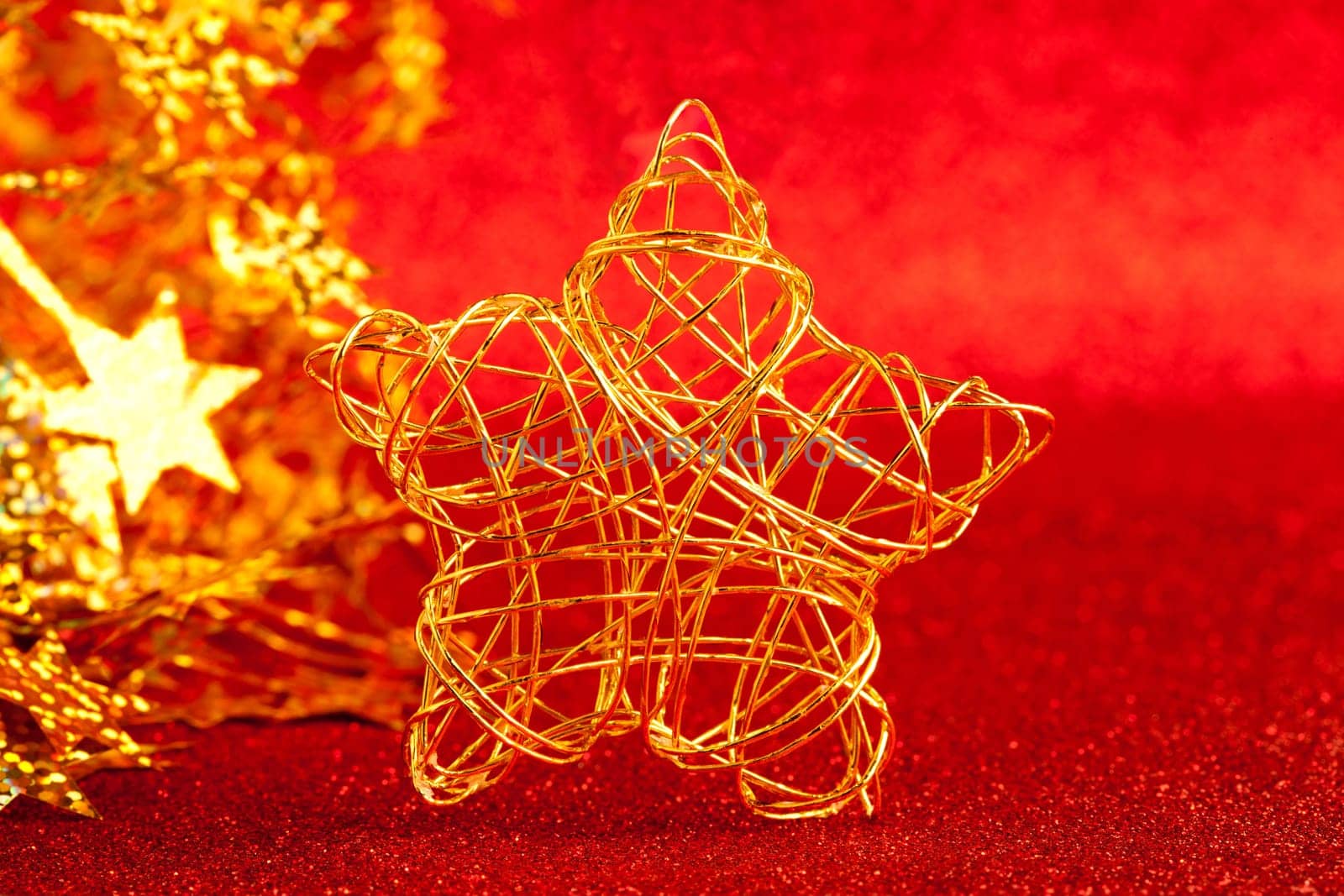christmas gold wire star on red glitter background