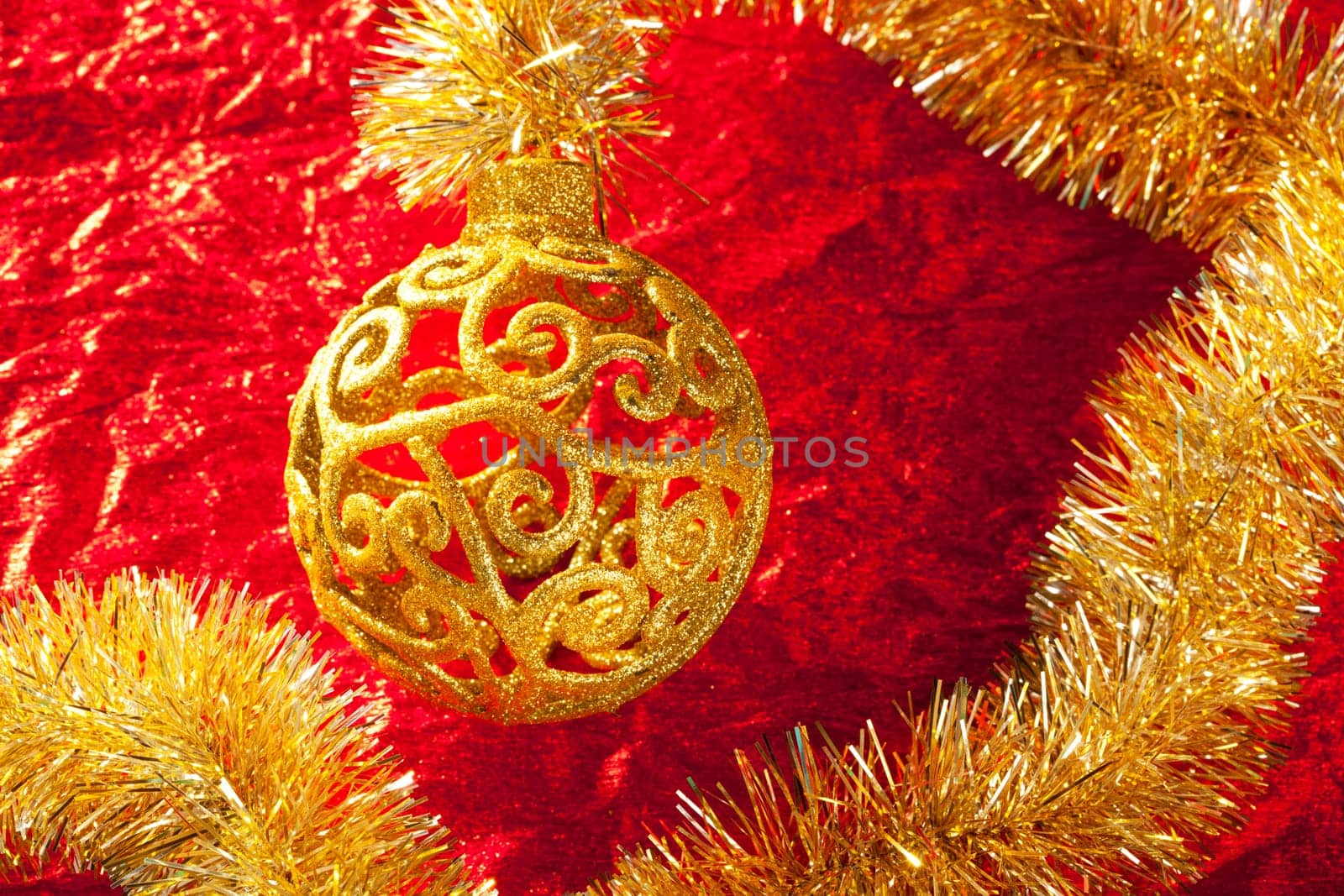 Christmas card golden bauble arabesque and tinsel on red background