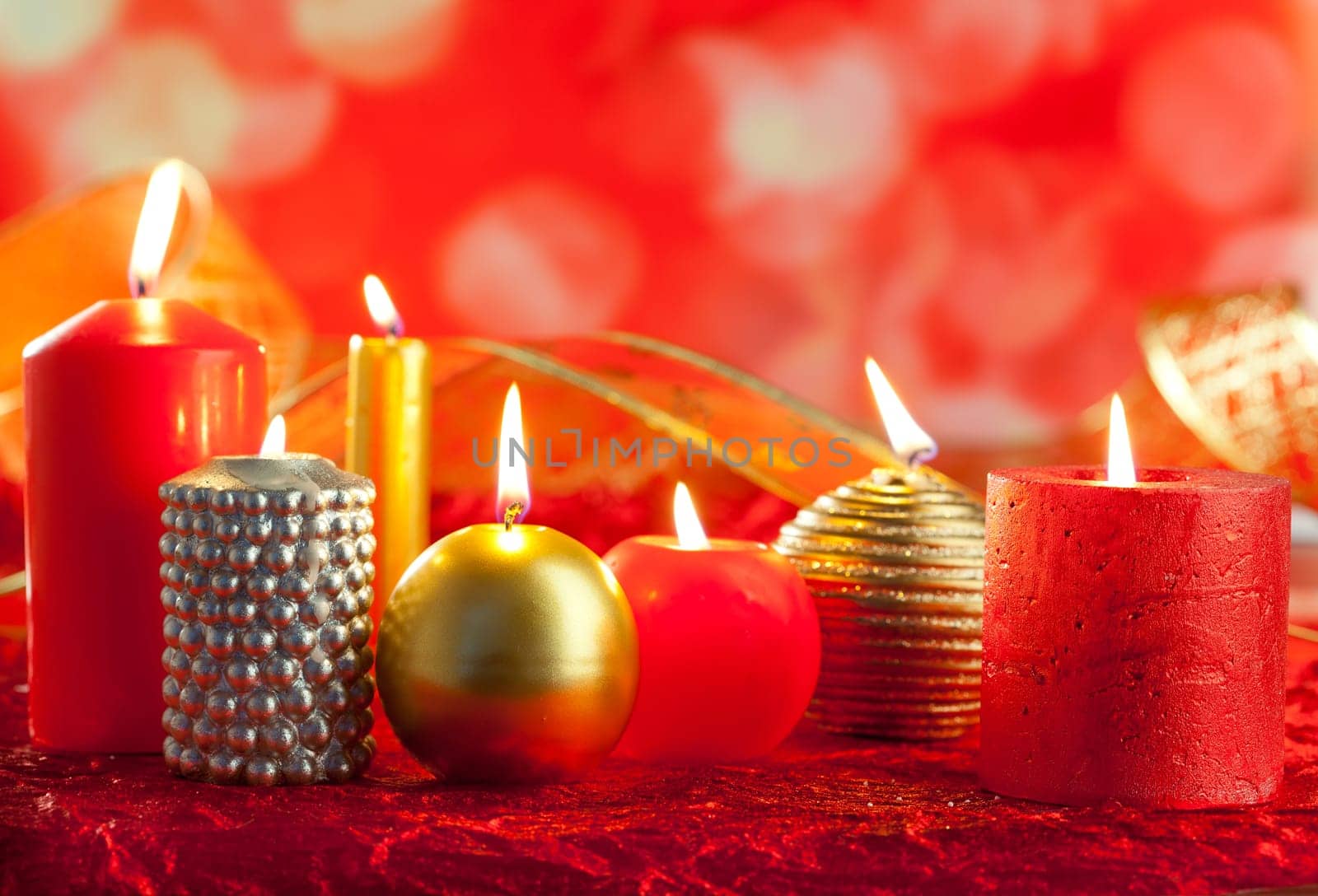 Christmas card candles red and golden in a row on blurred background