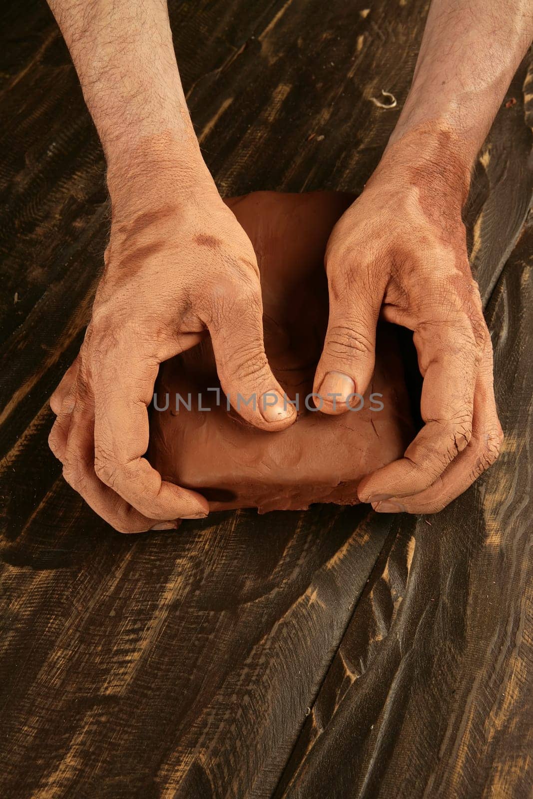 artist man hands working red clay to create handcraft art