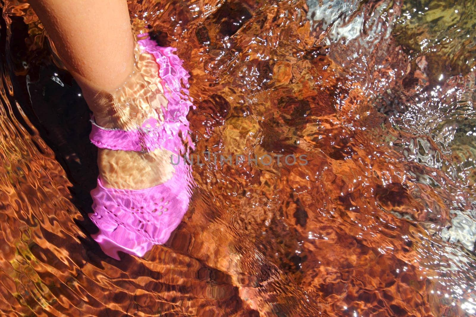 Girl water feet pink shoe in river stream red bottom rolling stones