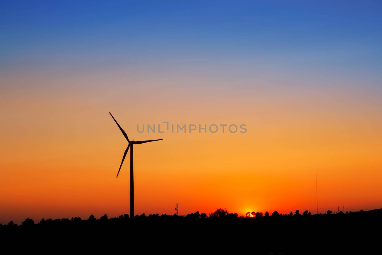 aerogenerator windmills on sunset sky background