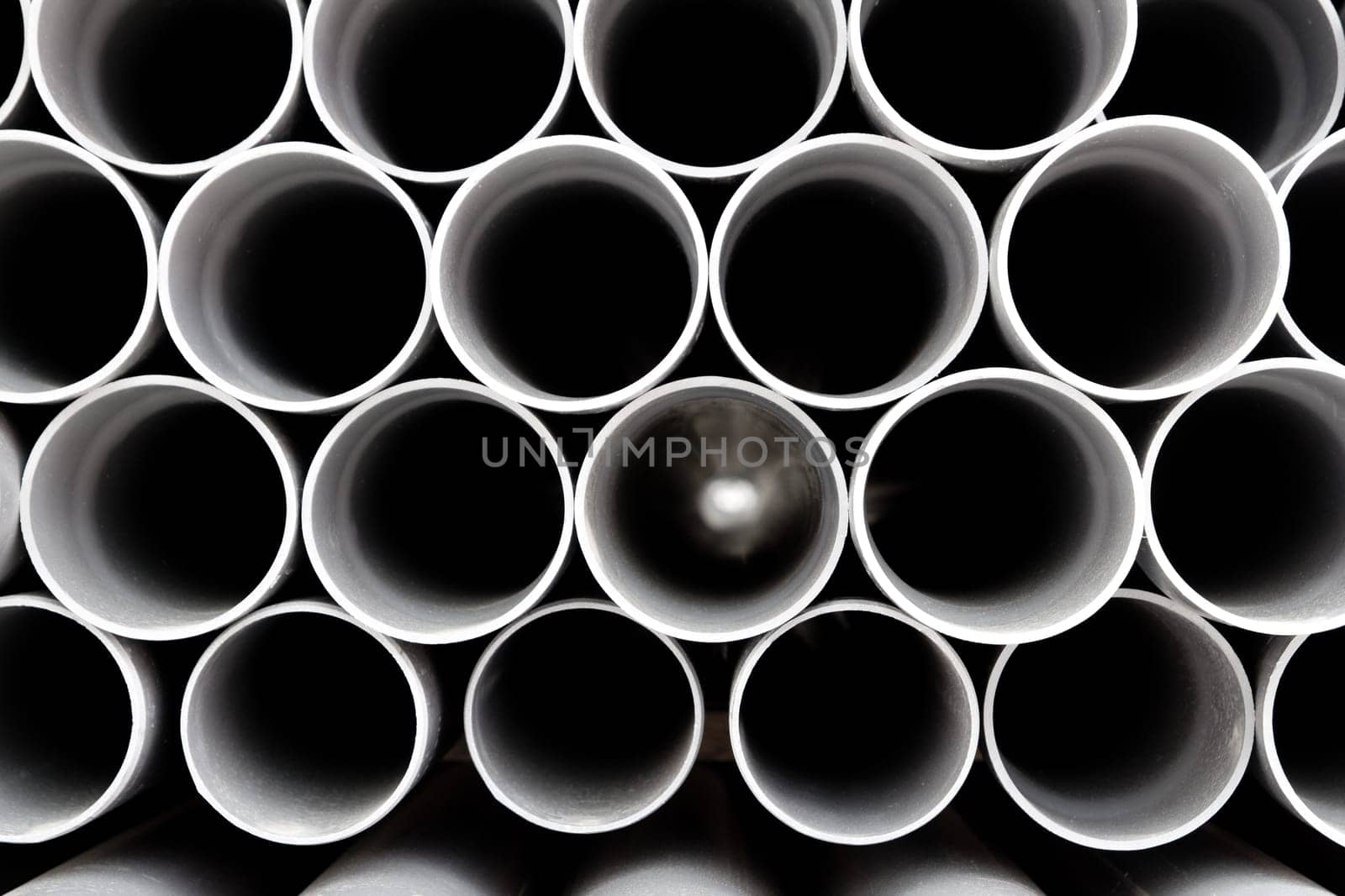 gray PVC tubes plastic pipes stacked in rows pattern