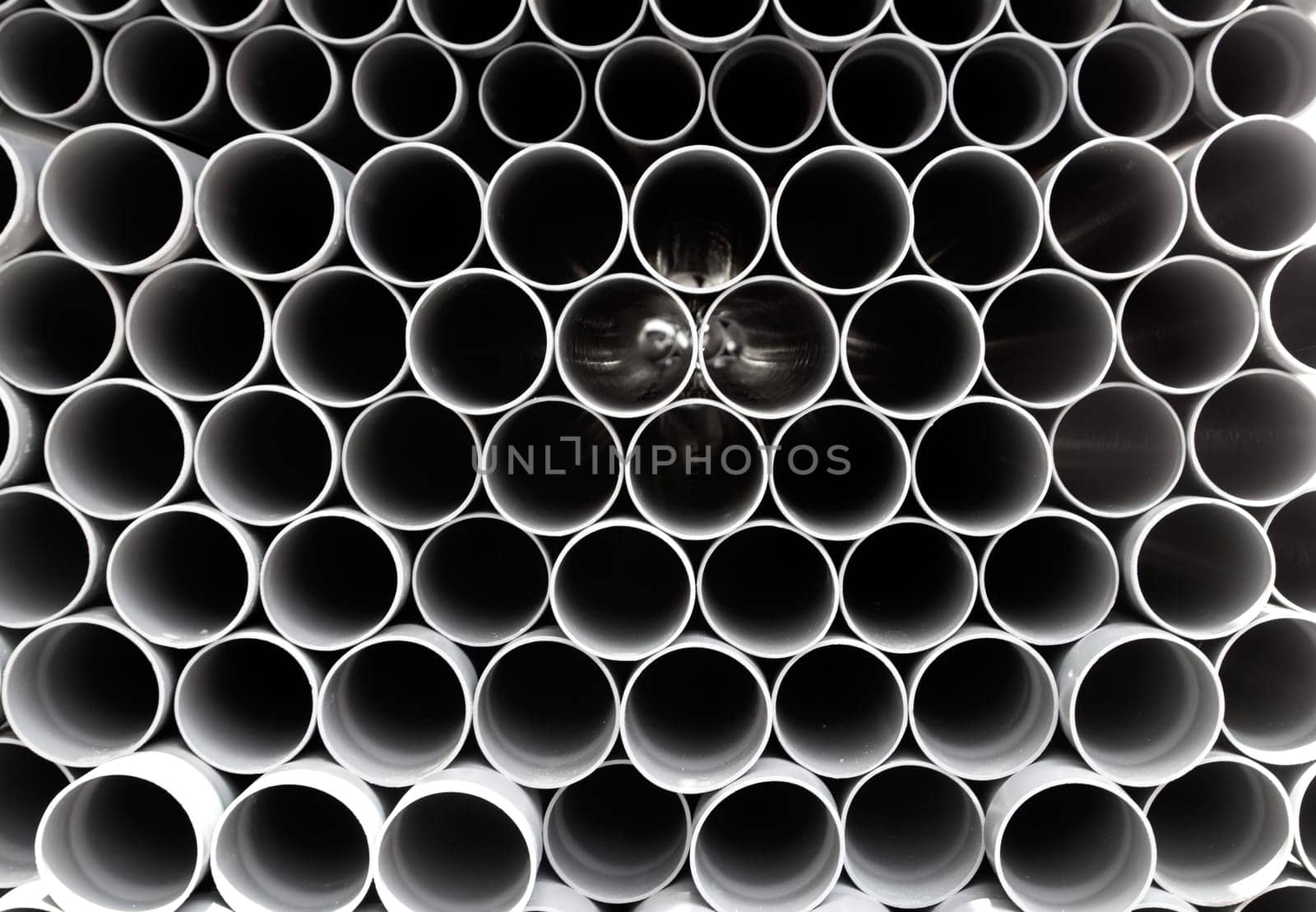 gray PVC tubes plastic pipes stacked in rows pattern