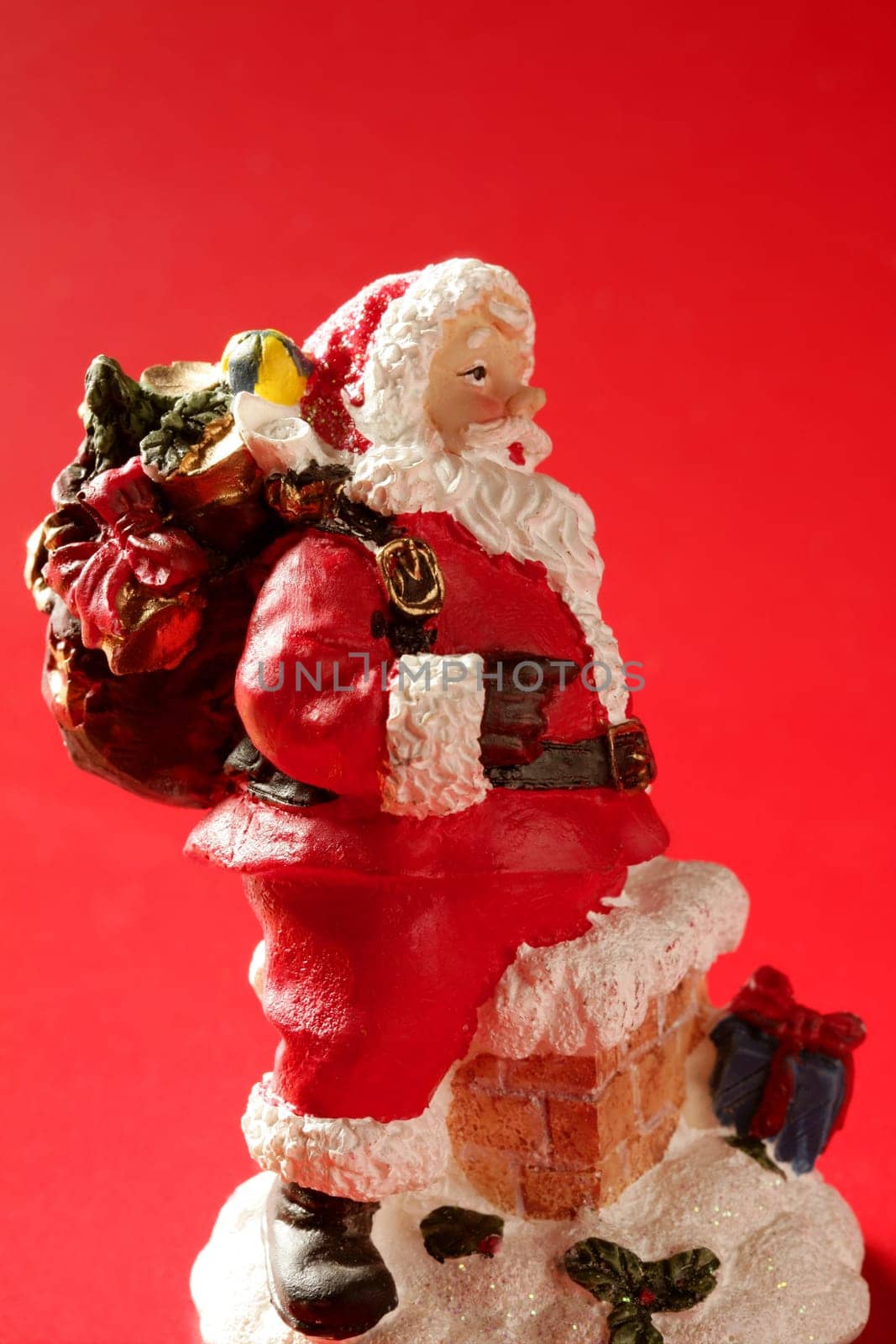Santa Claus figurine over red background, studio shot