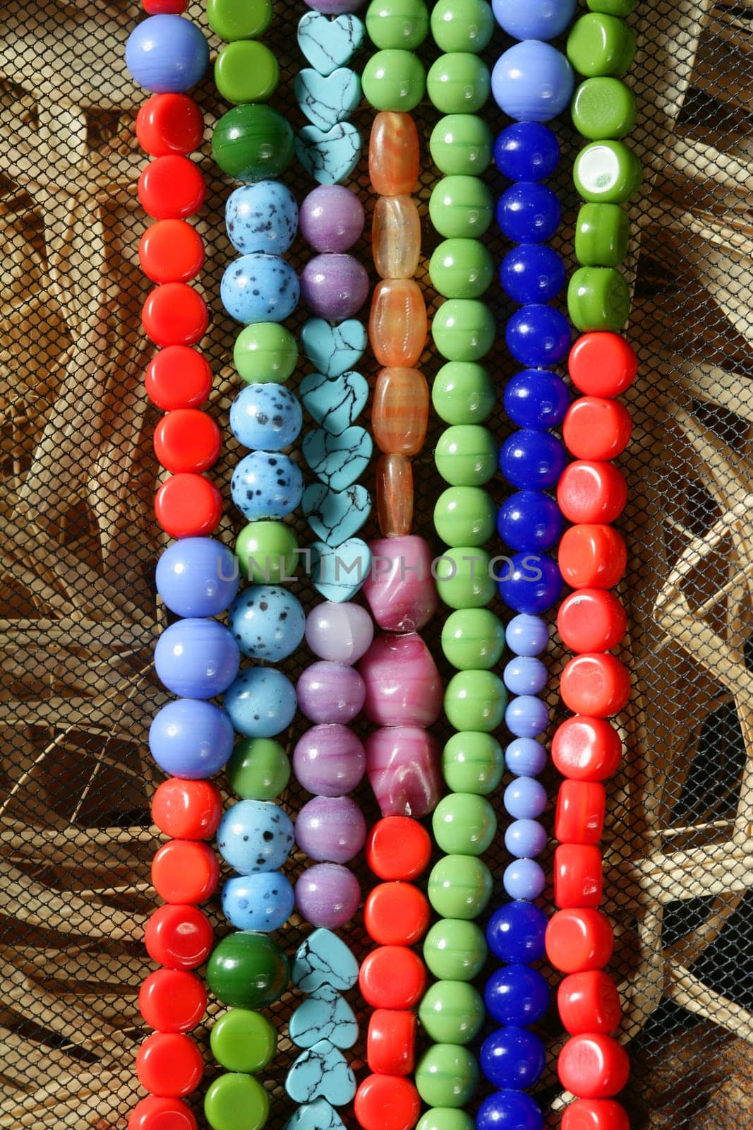 Color stones jewelry necklaces over natural straw and tulle background