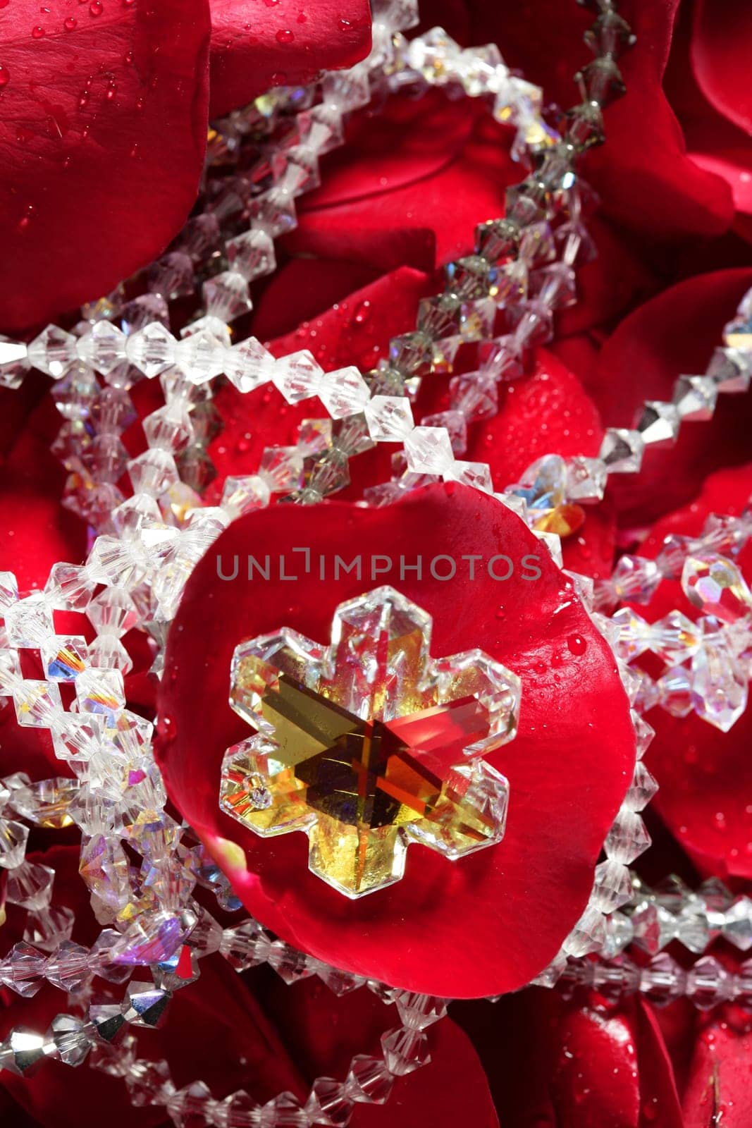 Shiny jewelry over bed or red rose petals