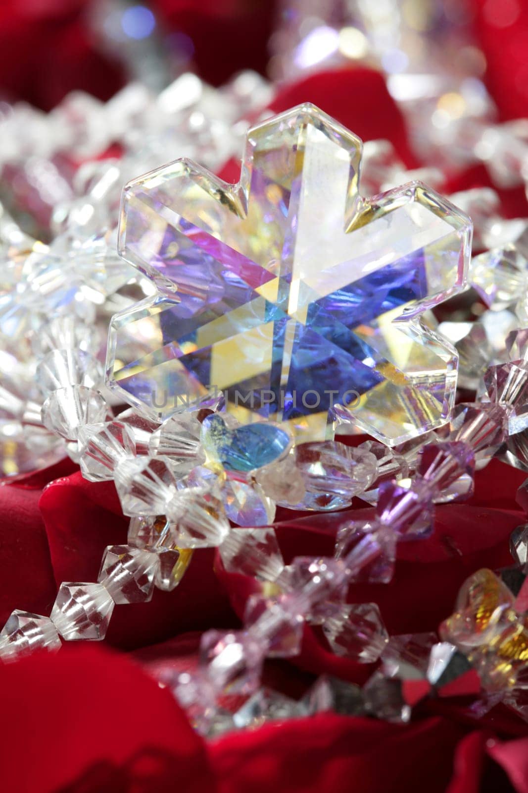 Shiny jewelry over bed or red rose petals