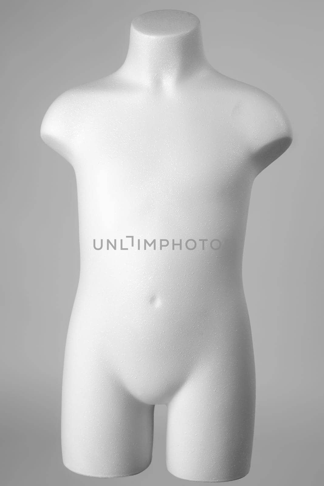 Mannequin of a child in white over gray background