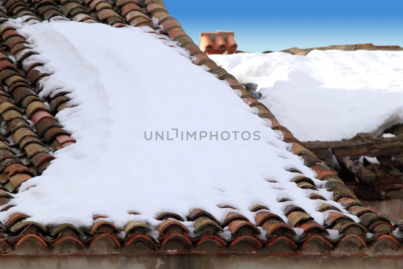 aged clay roof tiles snowed under snow architecture detail