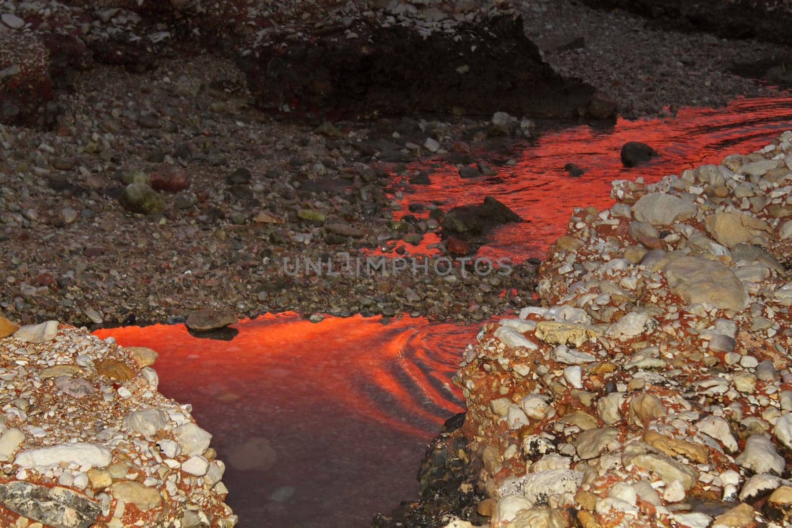 deep red sunset water reflexion on puddle sea shore