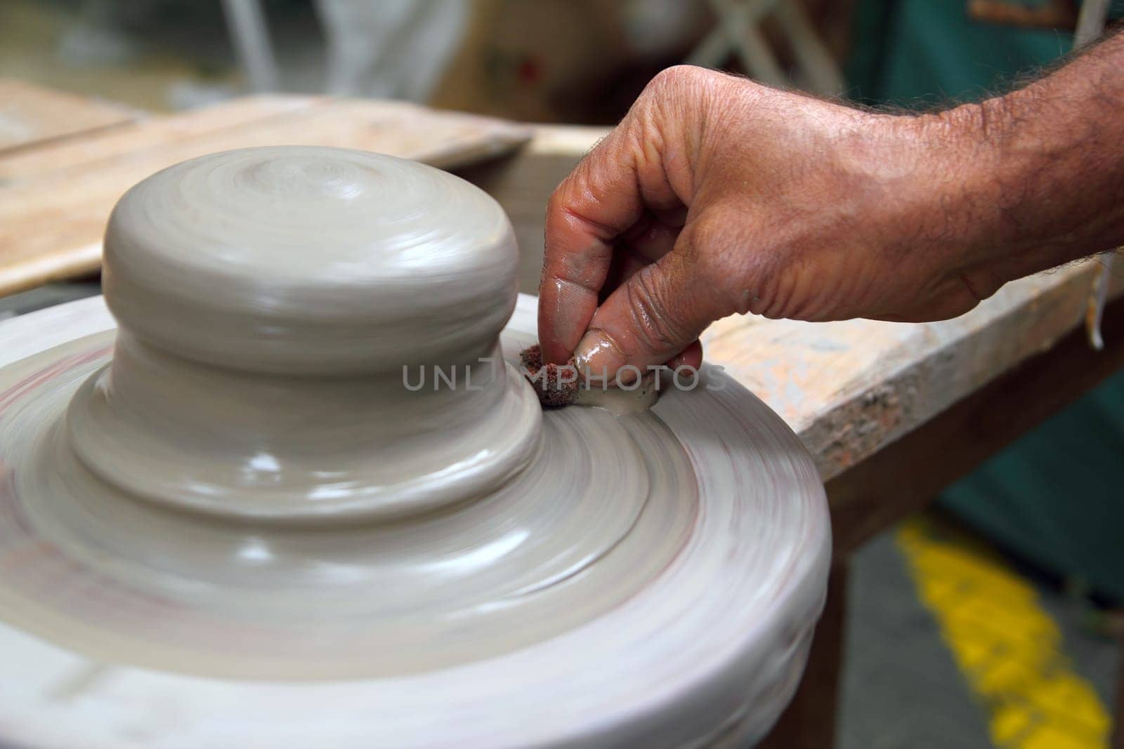 man potter hands working on pottery clay wheel stoneware sponge