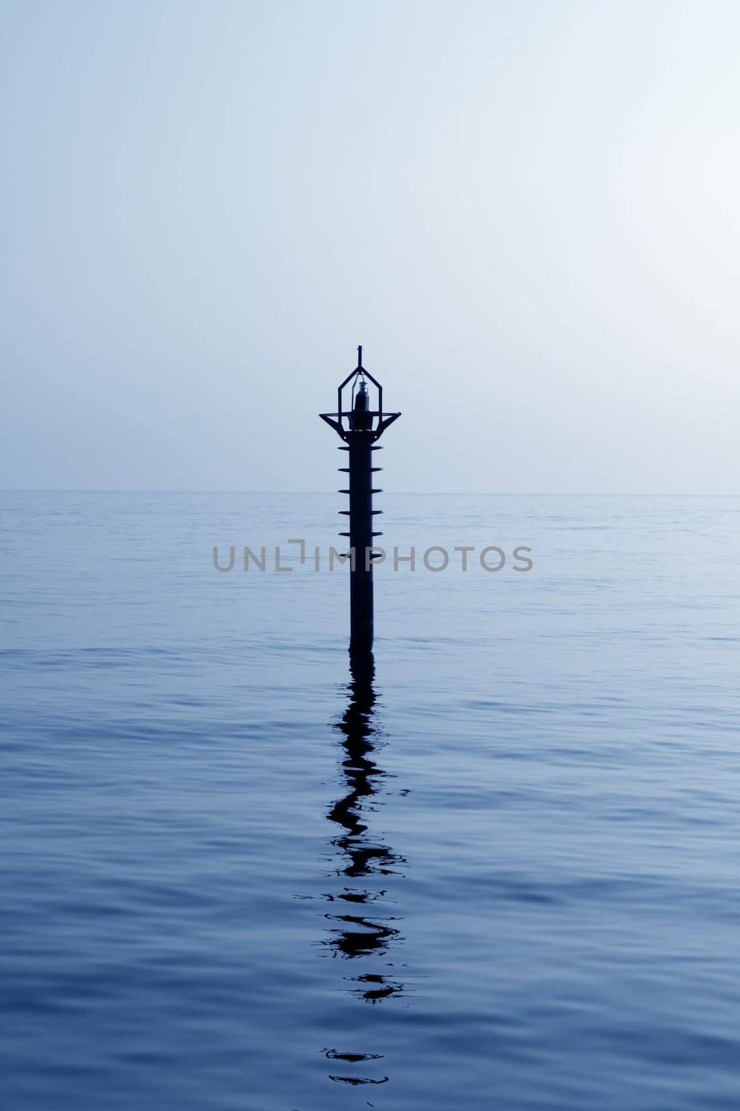 back light navigation beacon in Mediterranean blue sea water reflection