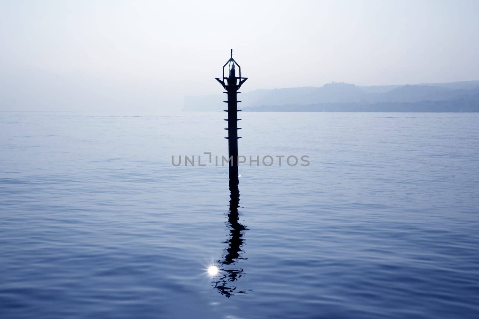 back light navigation beacon in Mediterranean blue sea water reflection