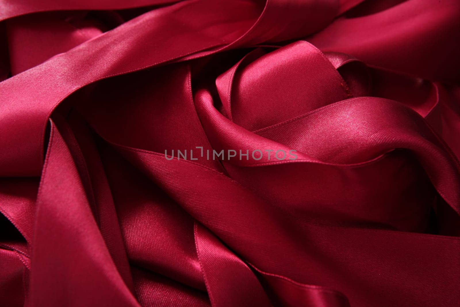 Red satin ribbons in a messy mess texture background