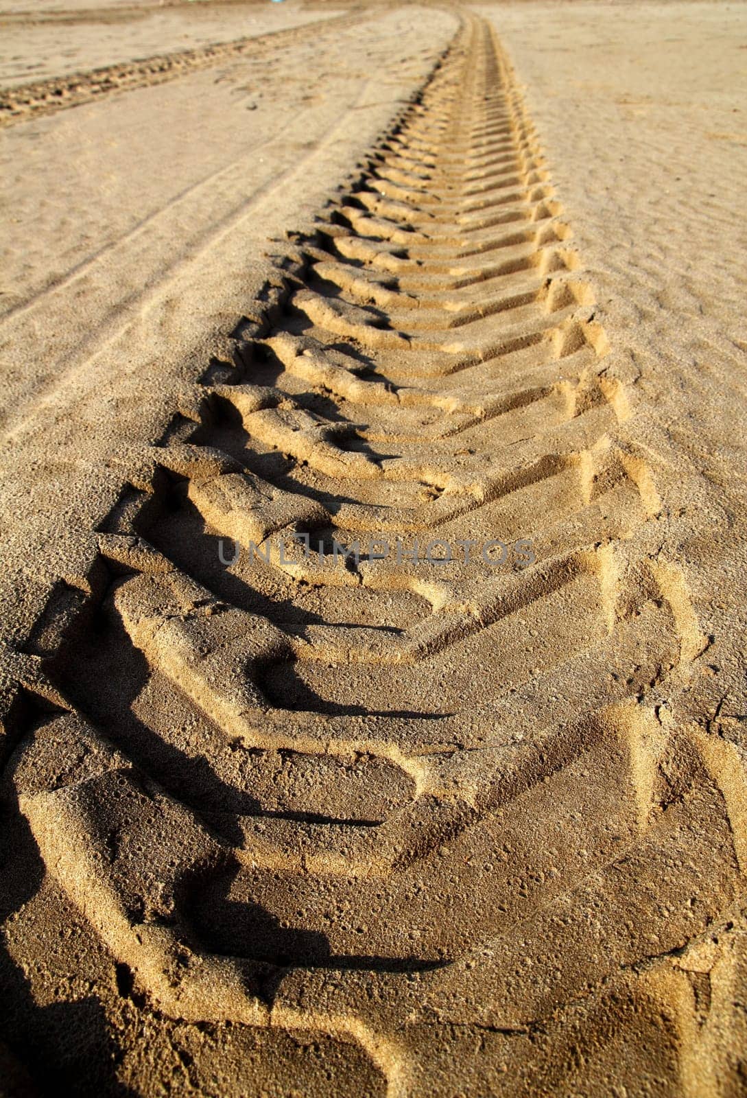 tractor tires pneus footprint printed on beach sand