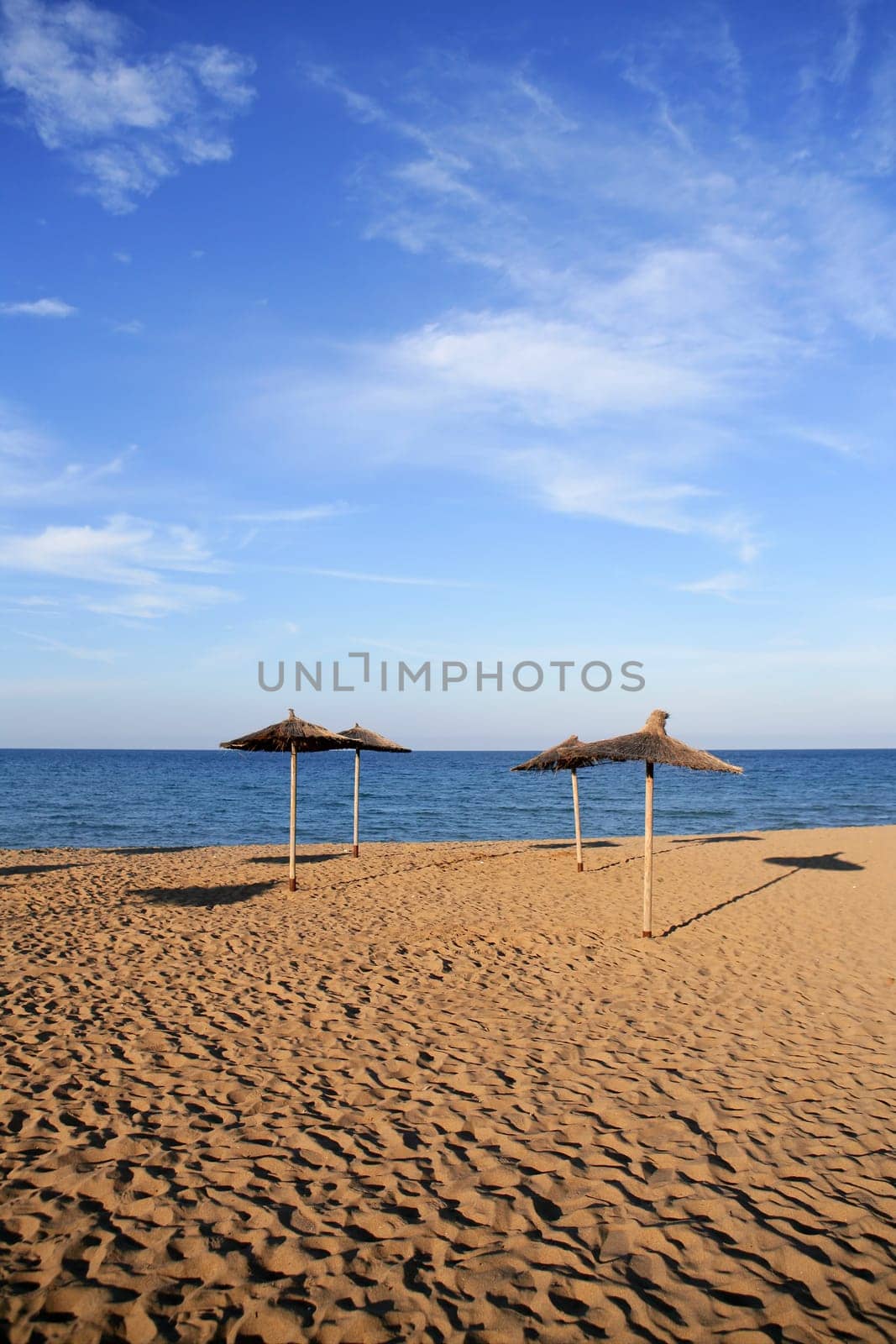 Blue beach in mediterranean sea with summer vacation umbrellas