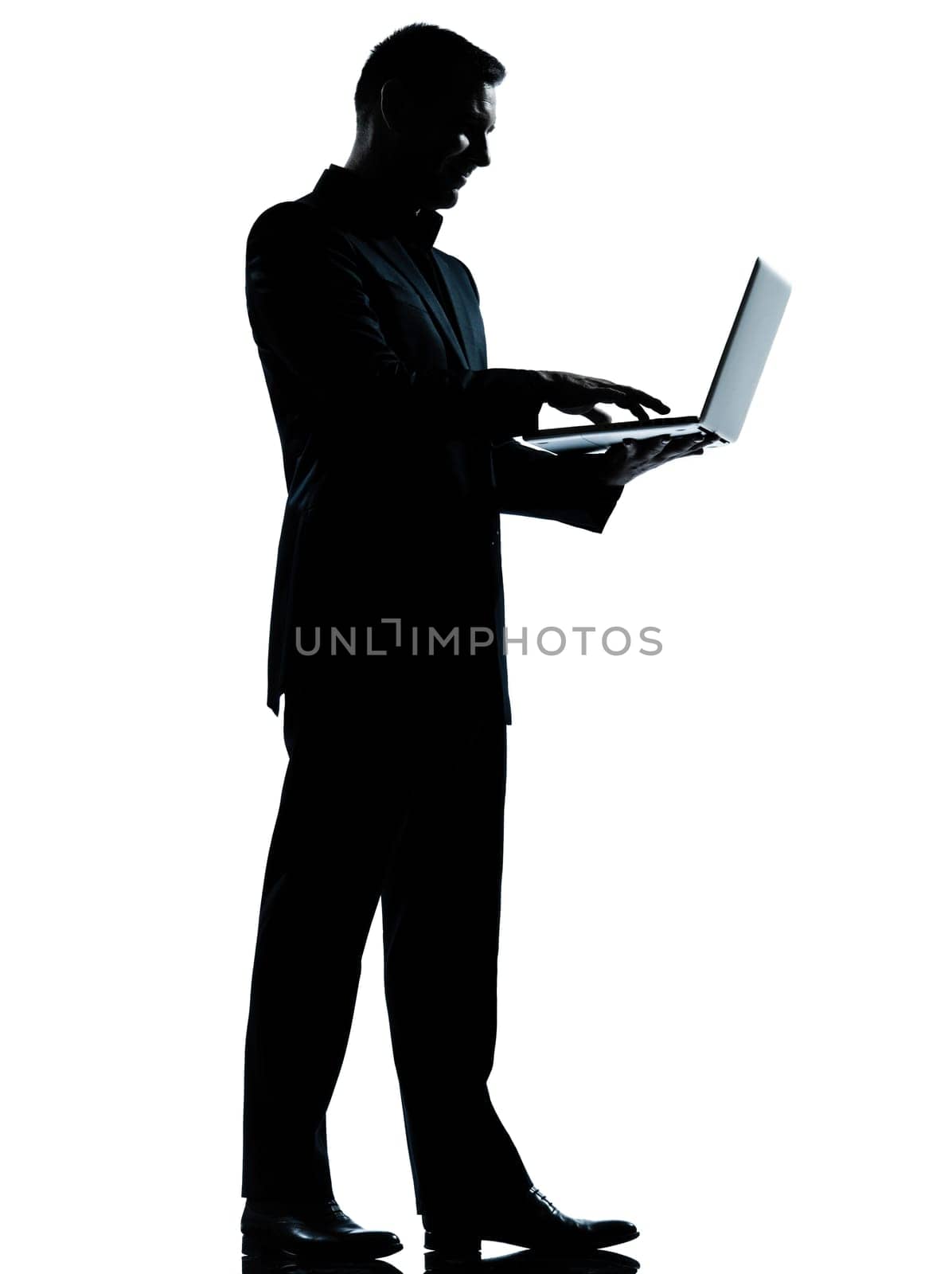 one caucasian business man computing computer laptop silhouette standing Full length in studio isolated on white background