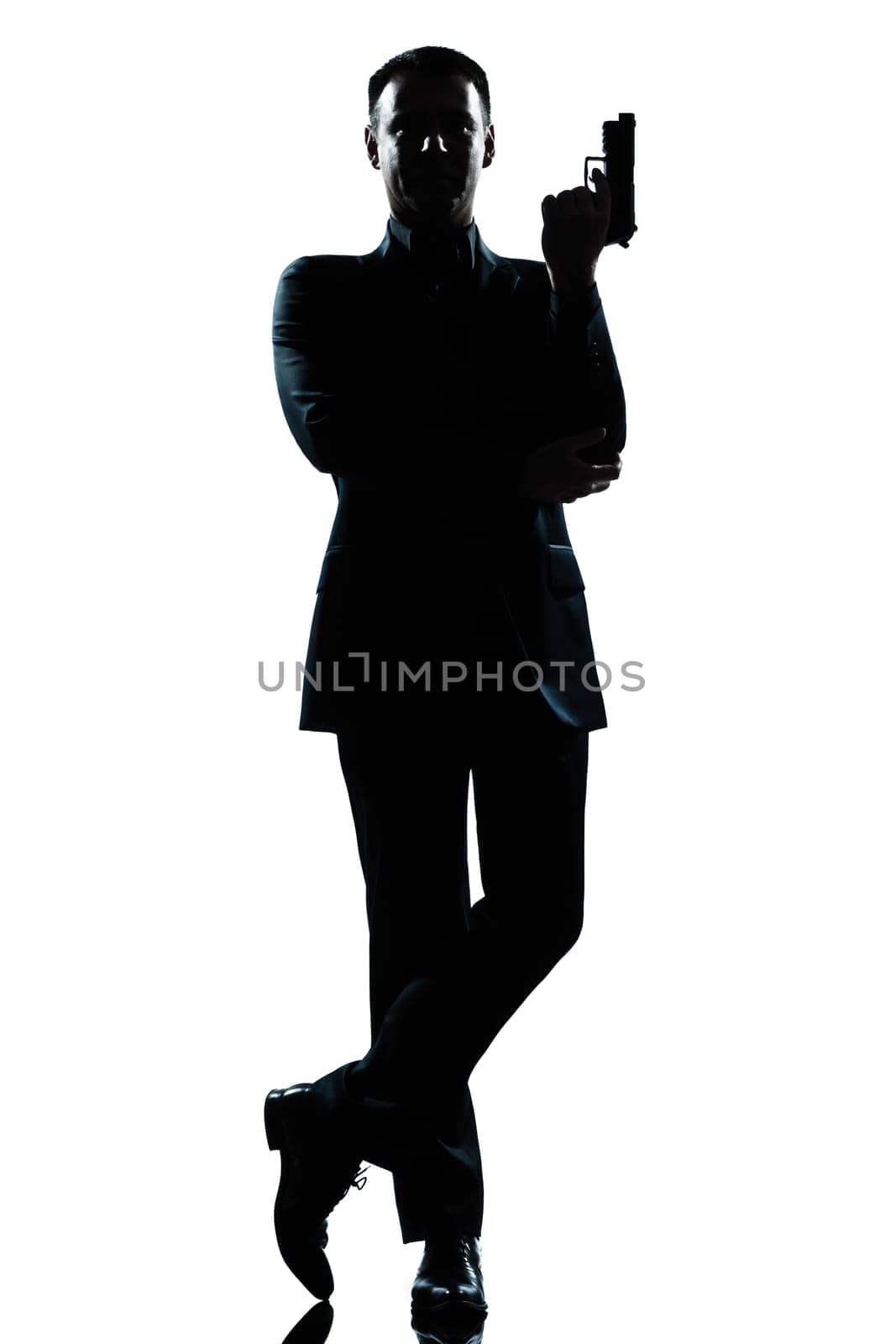 one caucasian secret agent in a james bond posture holding gun full length silhouette in studio isolated white background