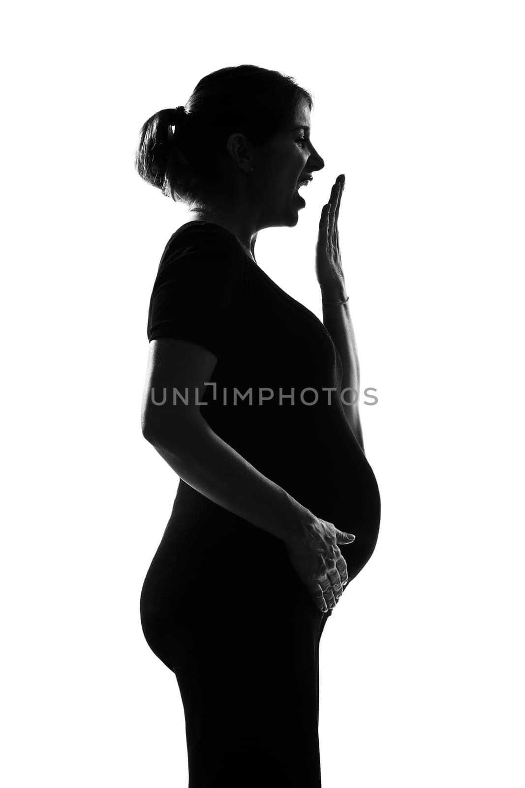 beautiful caucasian pregnant woman yawning tired in silhouette on studio isolated white background