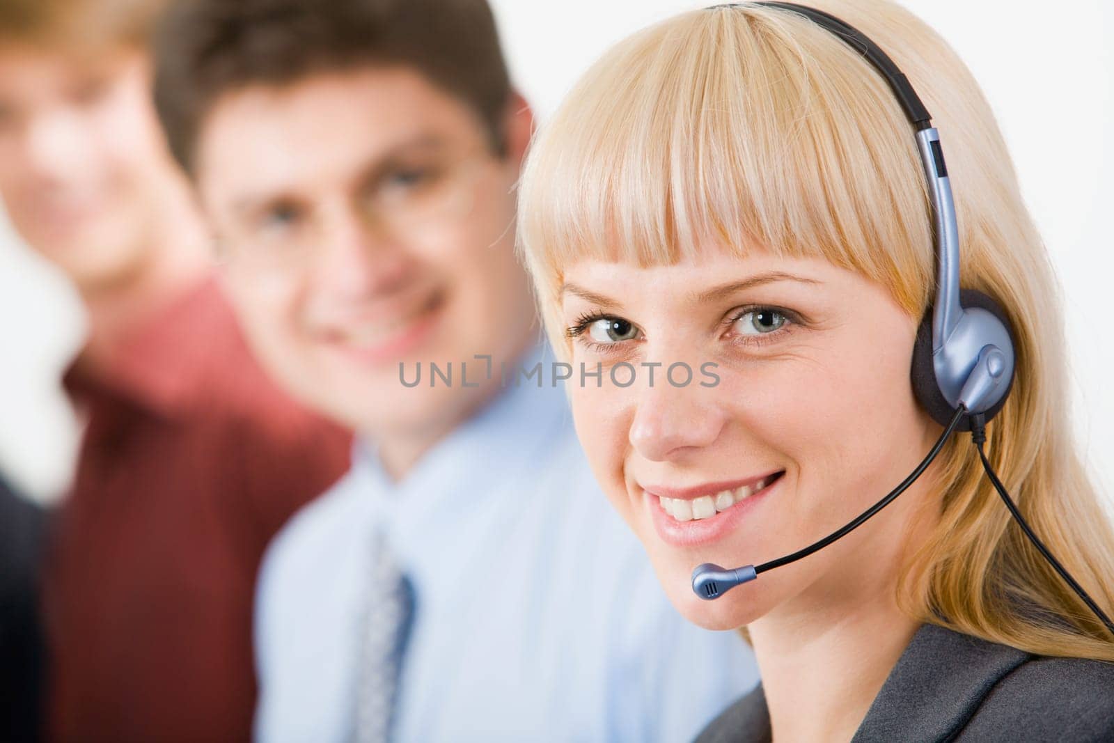 Portrait of friendly smiling telephone operator on the background of colleagues