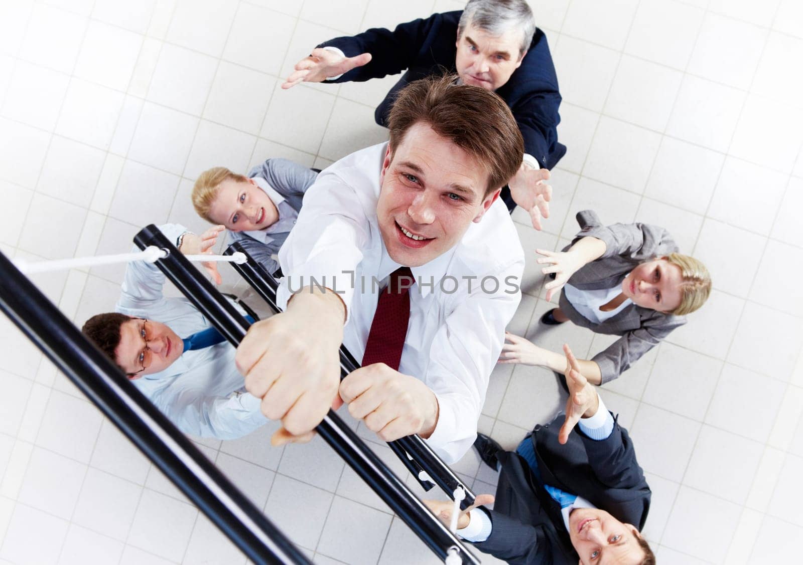 Above view of businessman ascending the ladder with his crew beneath