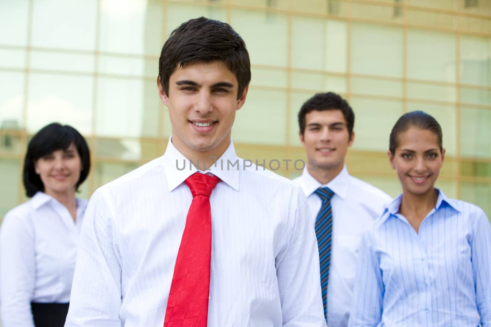 Portrait of smiling chief looking at camera on background of business team