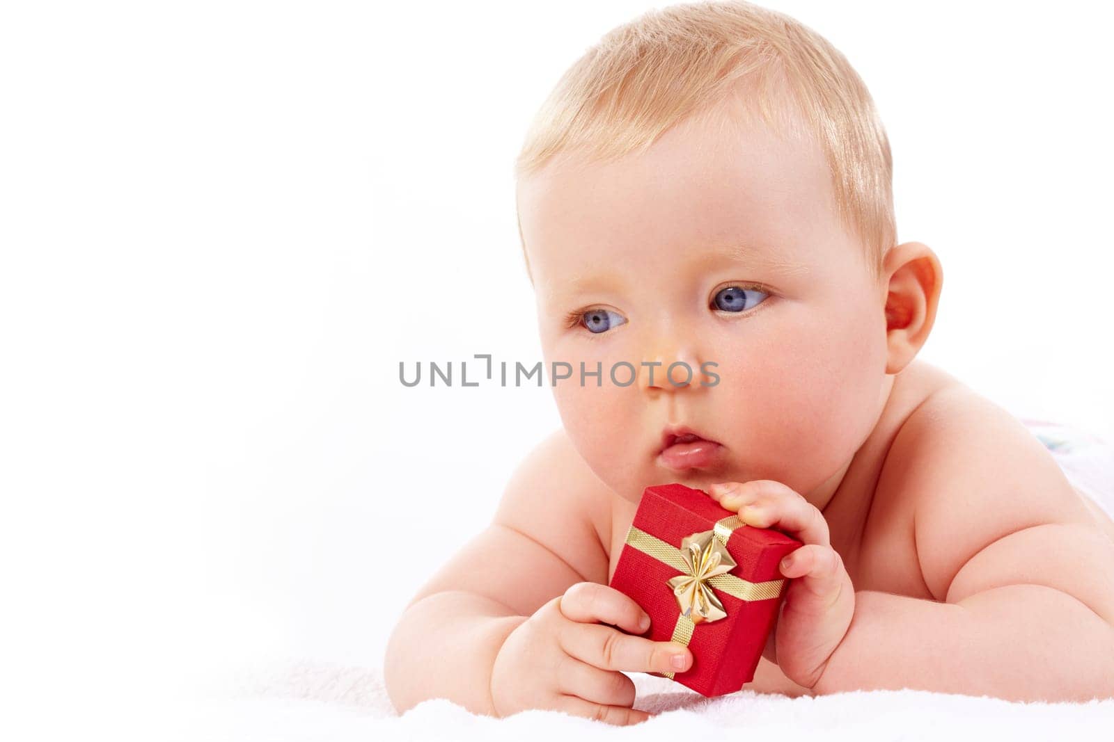 Portrait of pretty baby with red giftbox looking aside