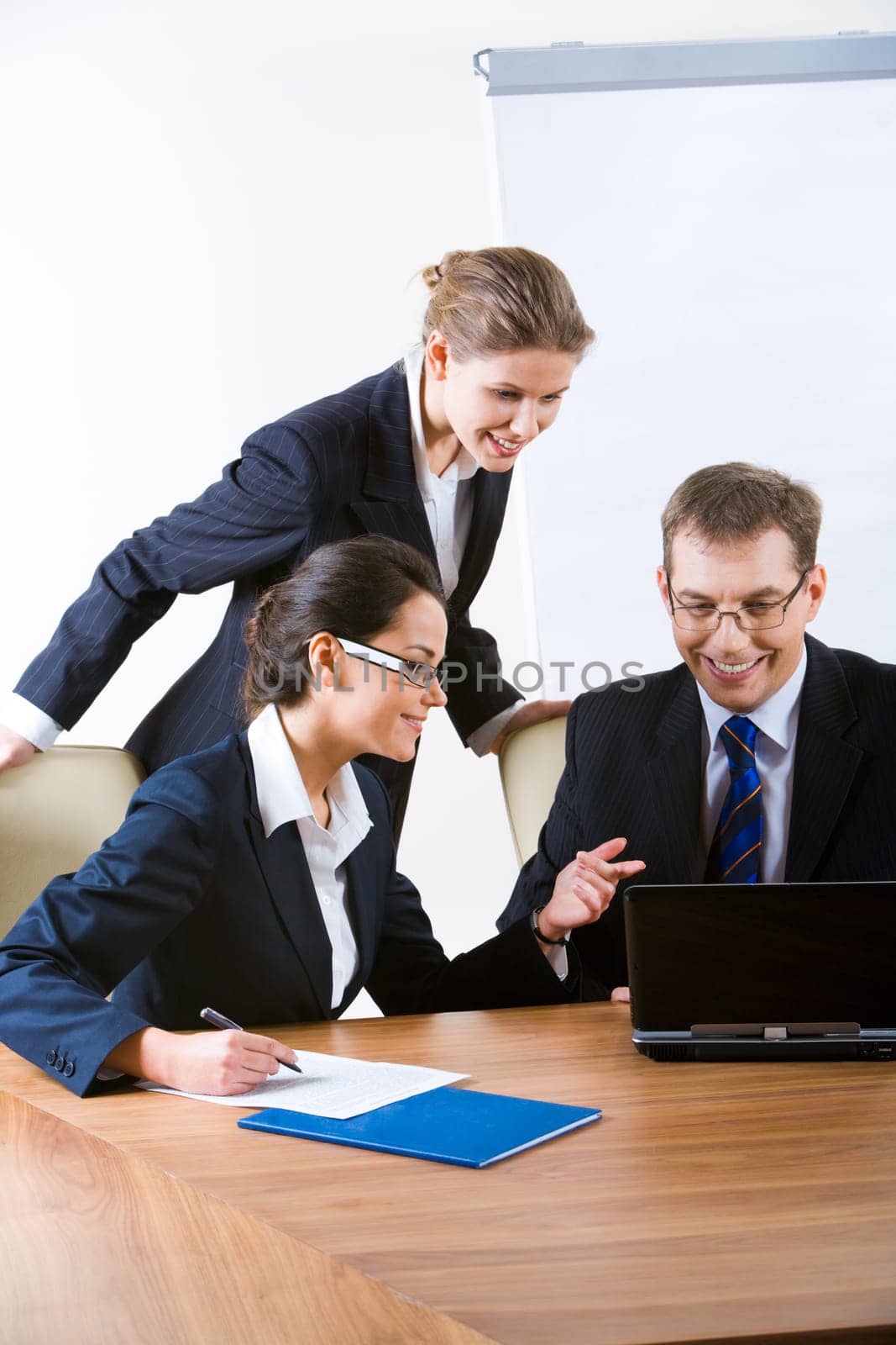 Image of three professionals discussing a computer work