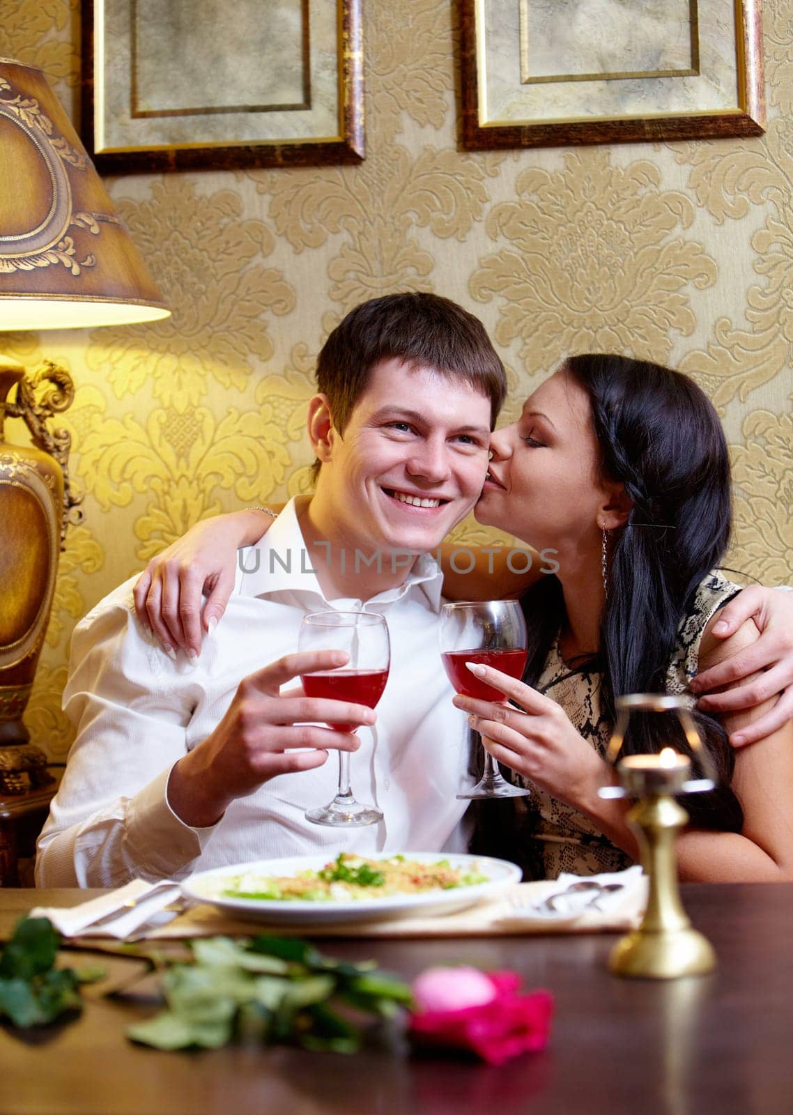 Portrait of woman kissing her boyfriend in the restaurant