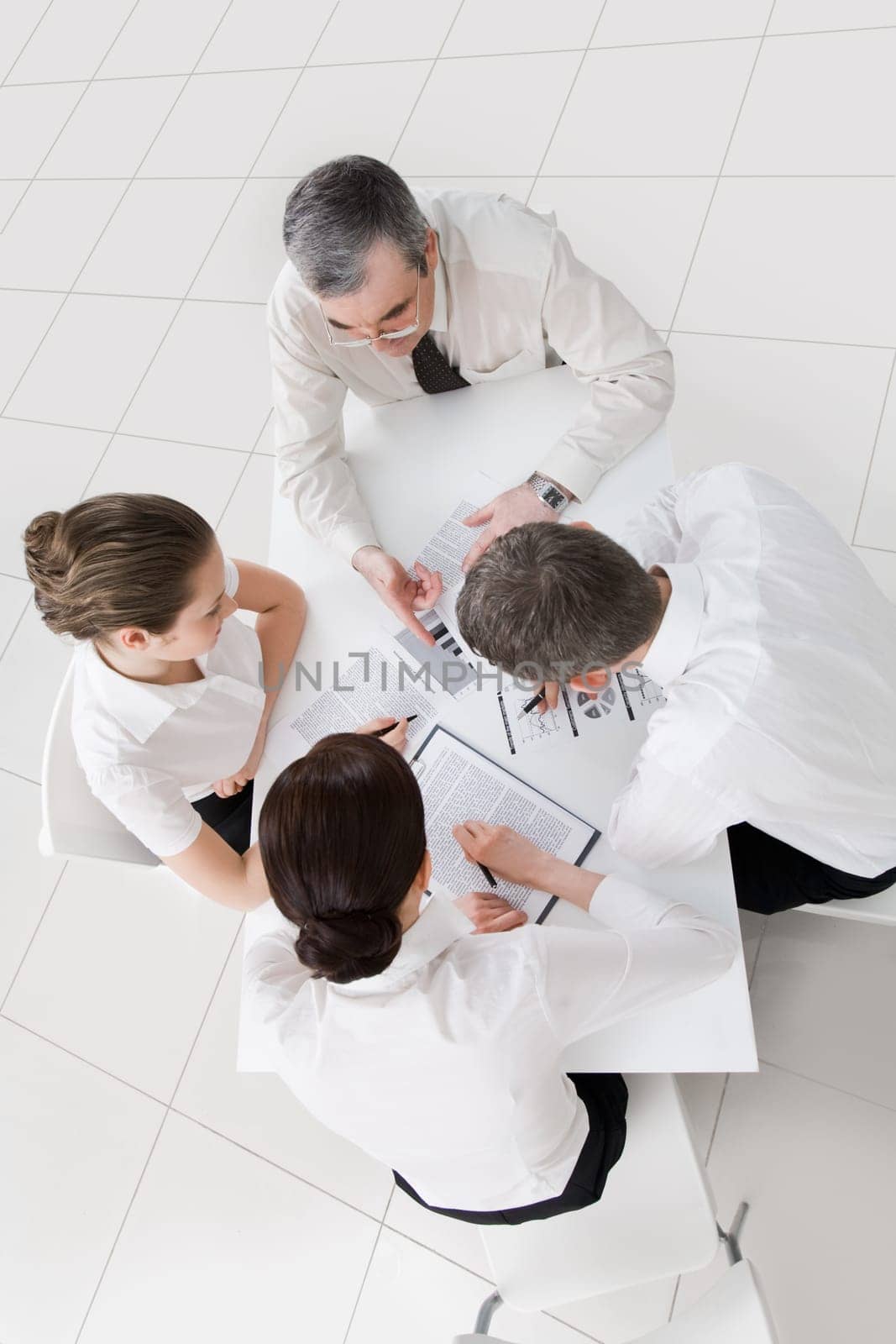 Above view of friendly workteam discussing new ideas at meeting