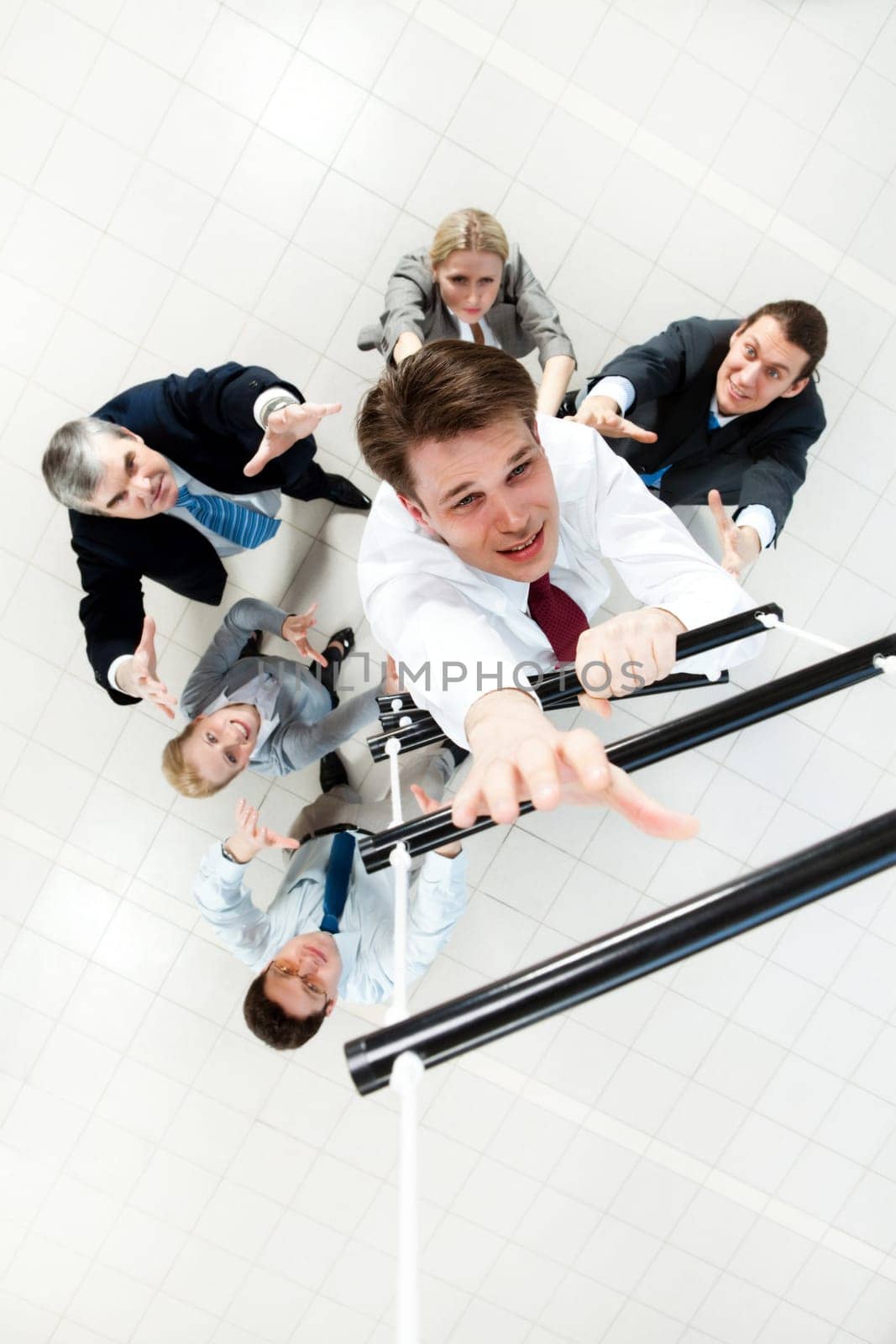 Above view of businessman ascending the ladder with his crew beneath
