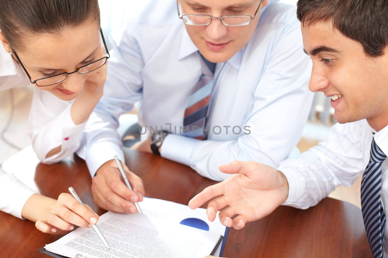 Three business people examining documents