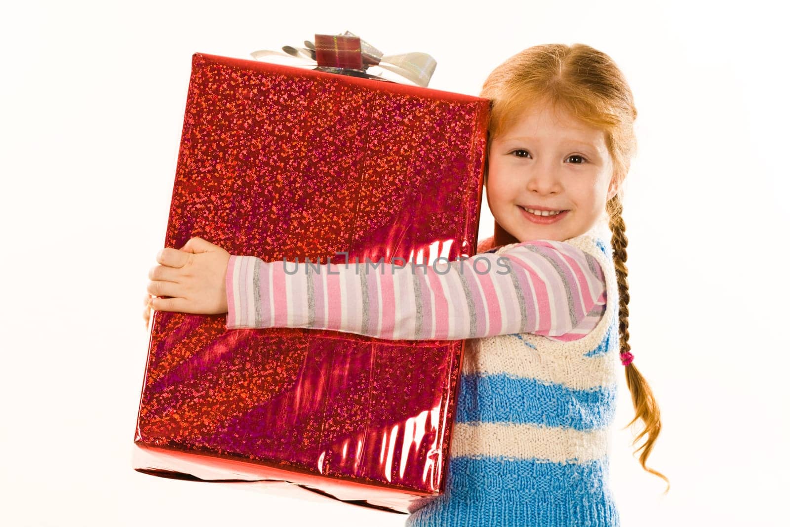 Image of glad child embracing very big giftbox with her present and smiling